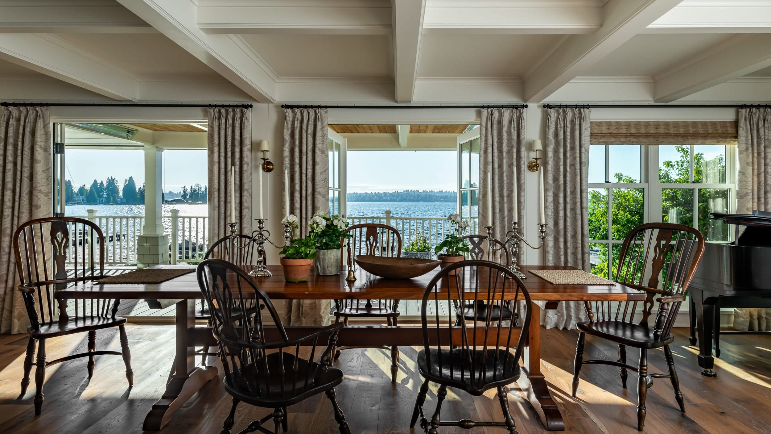 A dining room with large windows overlooking the water.