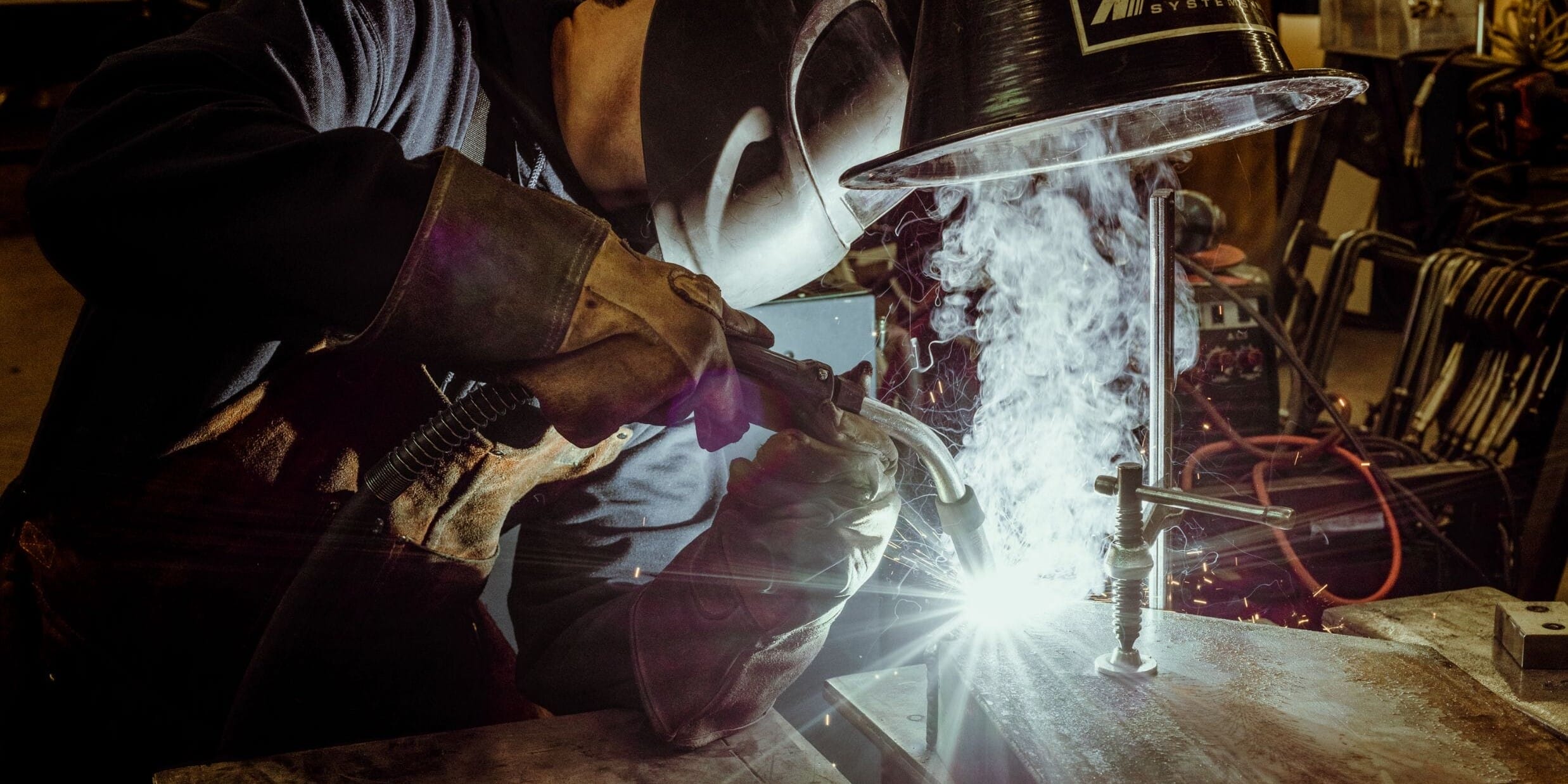 A welder at Dyna Metal Shop Seattle working on a piece of metal.