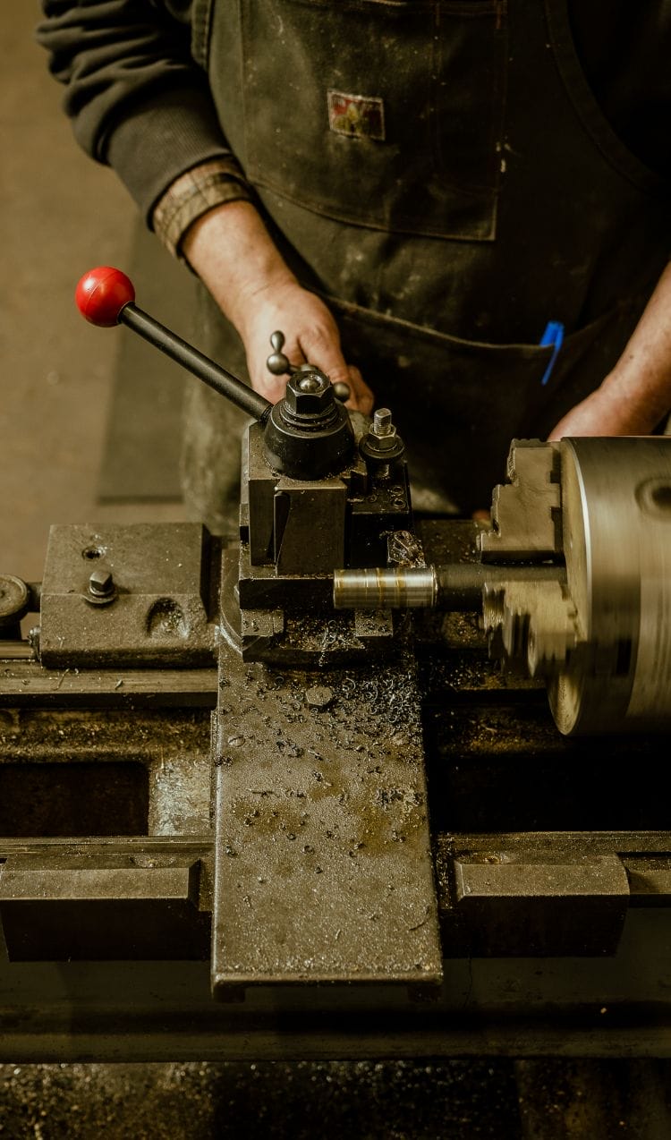 A man working on a lathe machine at Dyna Builders in Seattle.