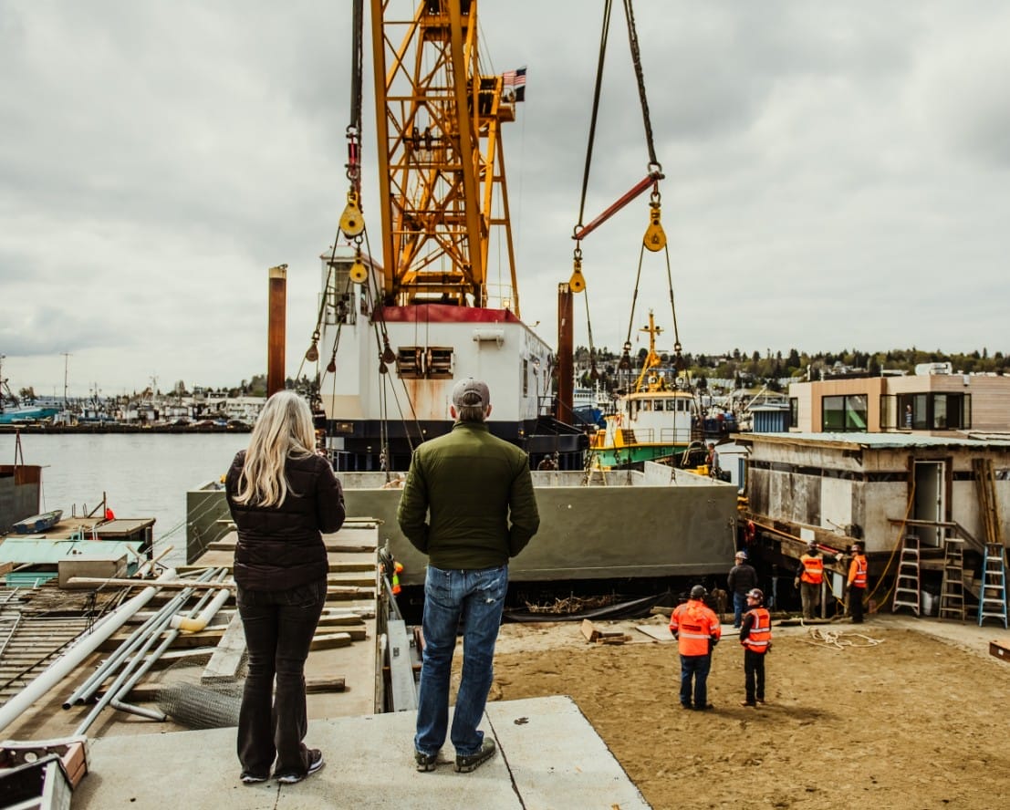 About Dyna Seattle Home Builders - A group of people standing in front of a crane.