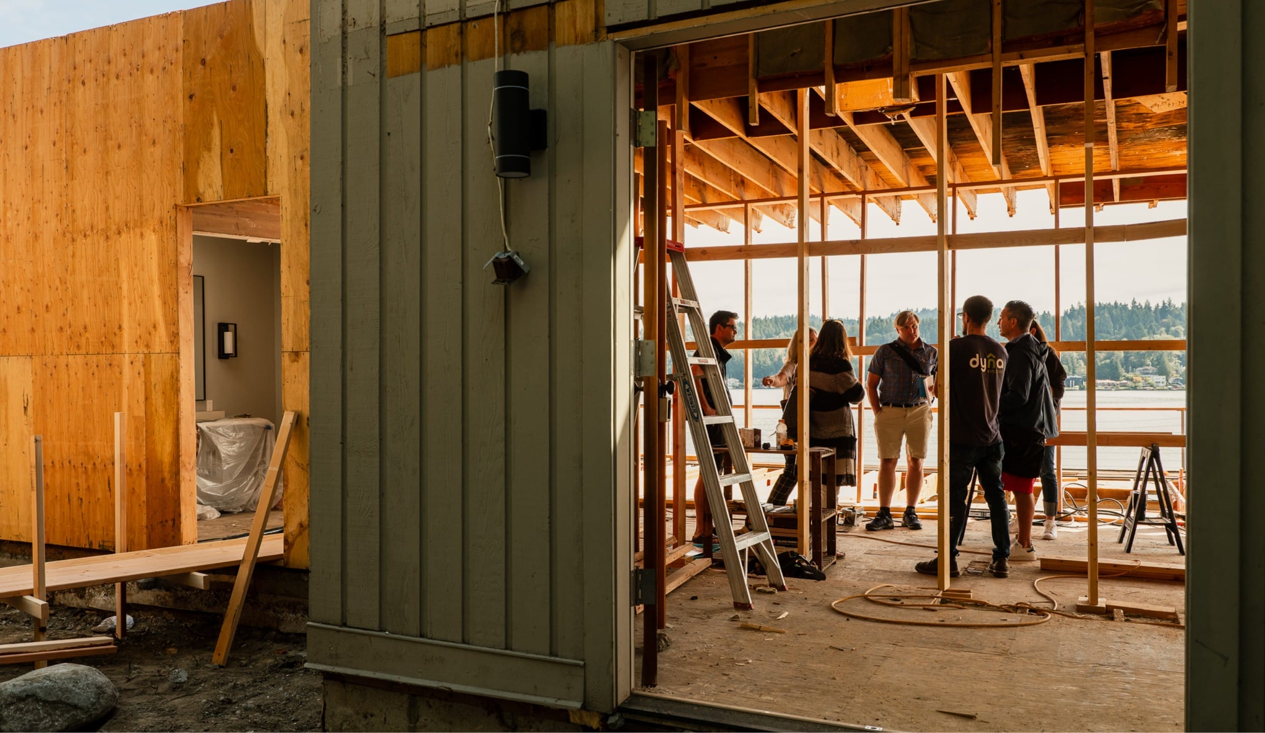 A group of people standing in the doorway of a house under construction, built by Dyna Builders, a Seattle based custom home builder.