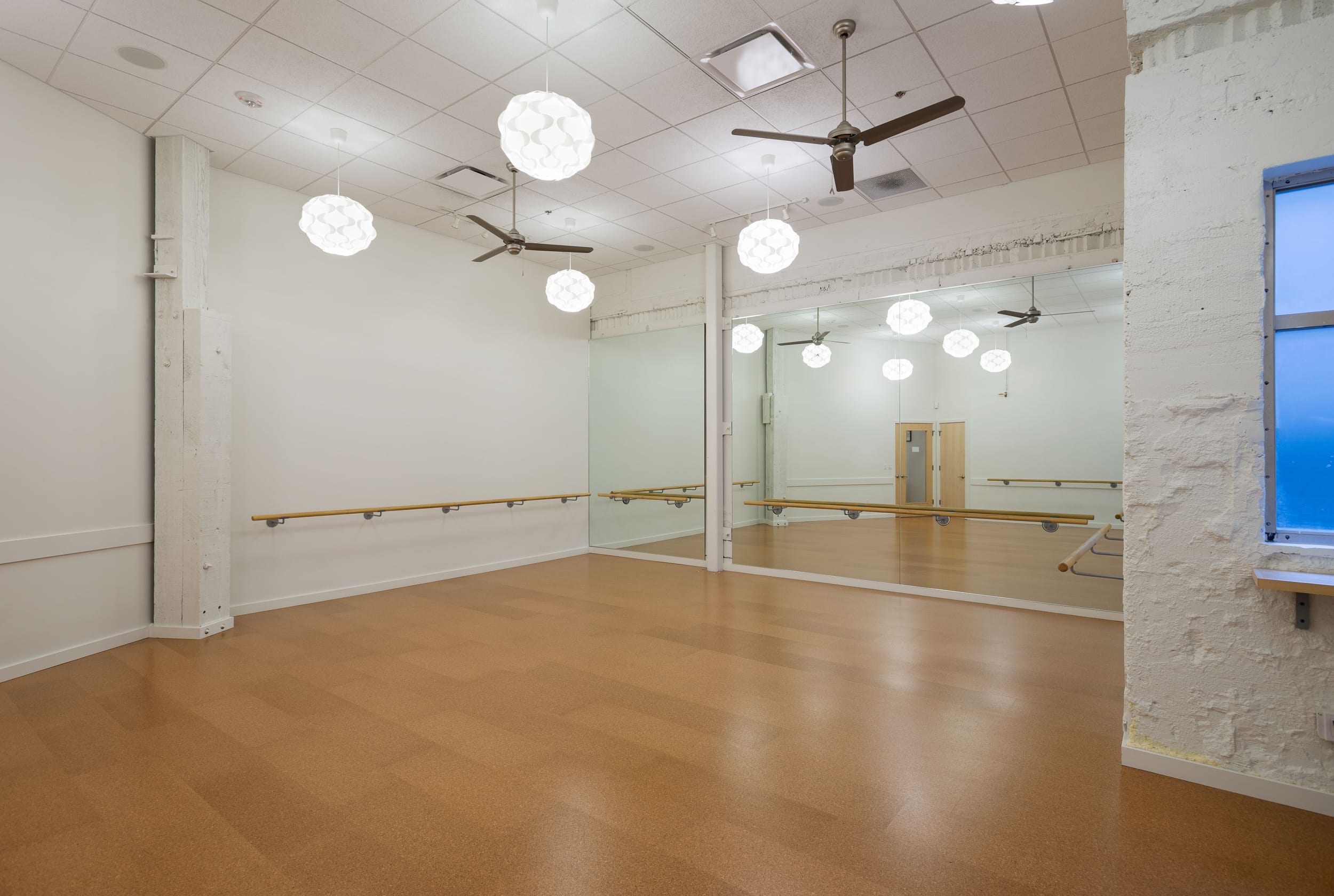 An empty dance studio with mirrors and lights.