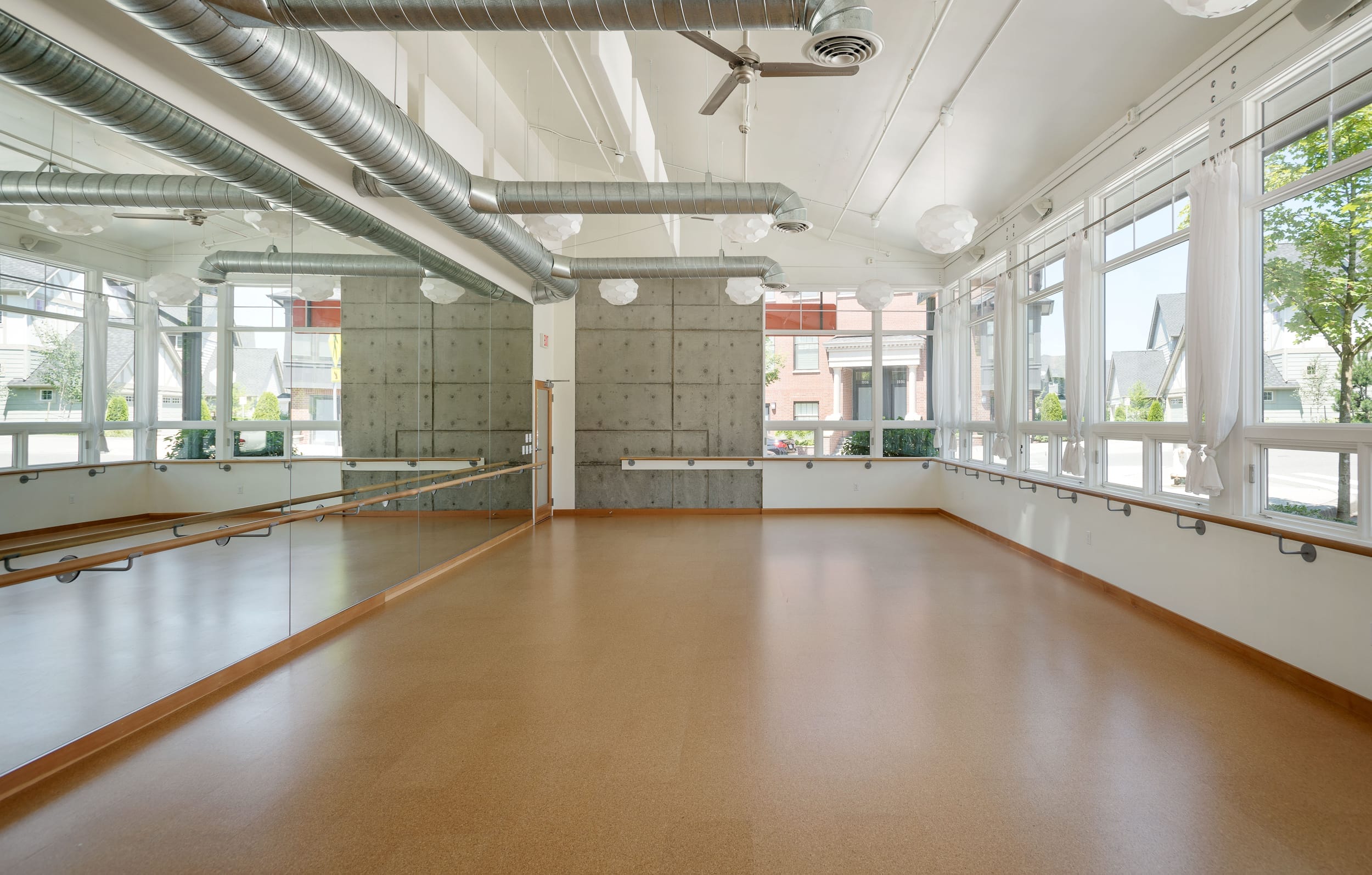 An empty dance studio with large windows.