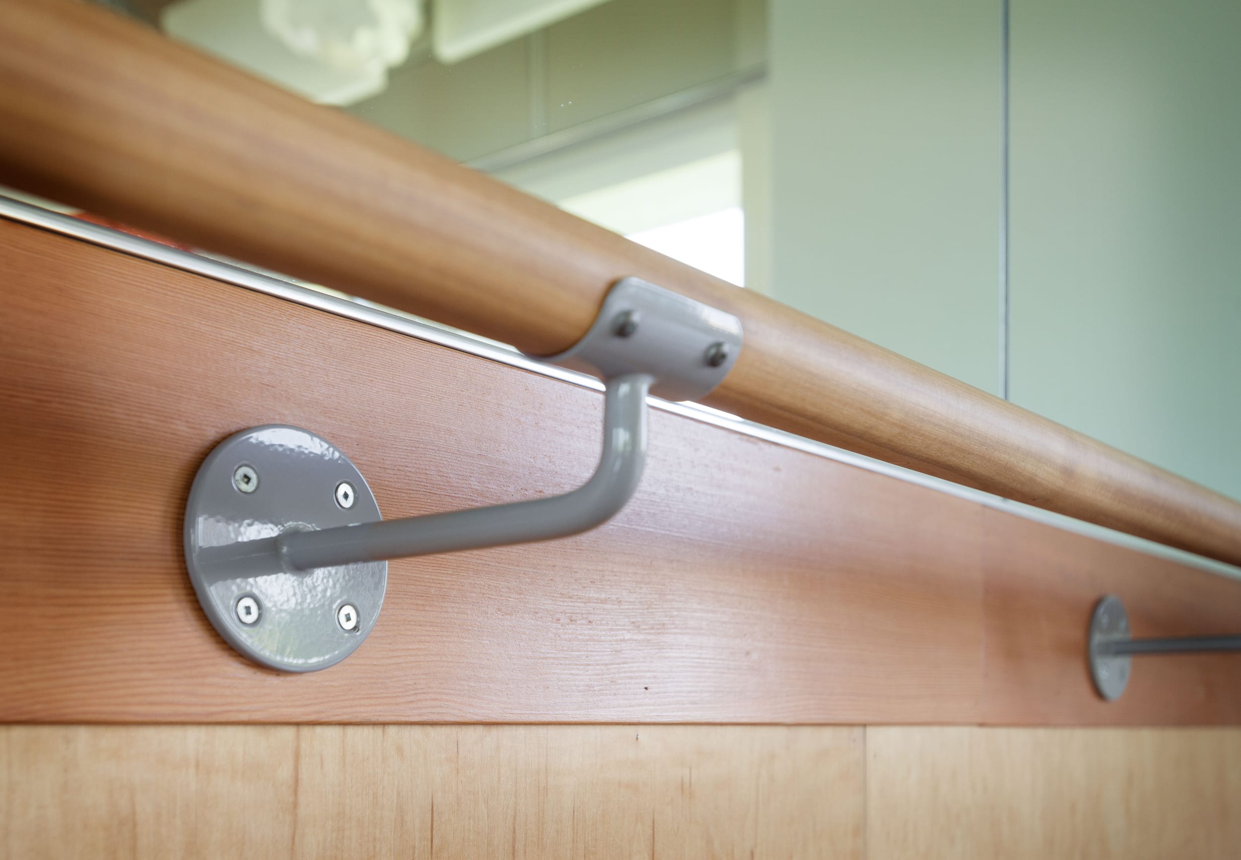 A wooden railing with metal handles on it.