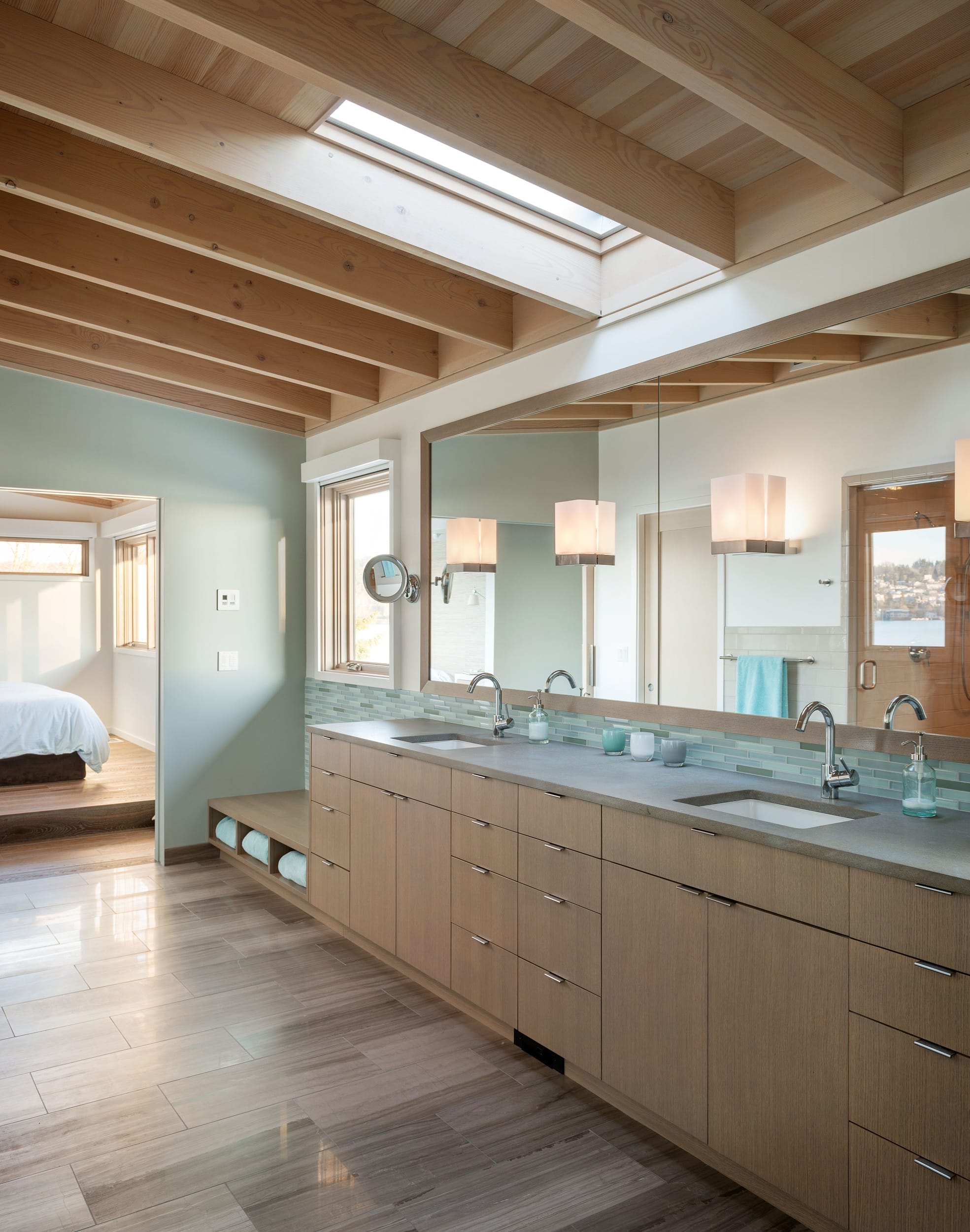 A bathroom with a skylight and wooden ceiling.