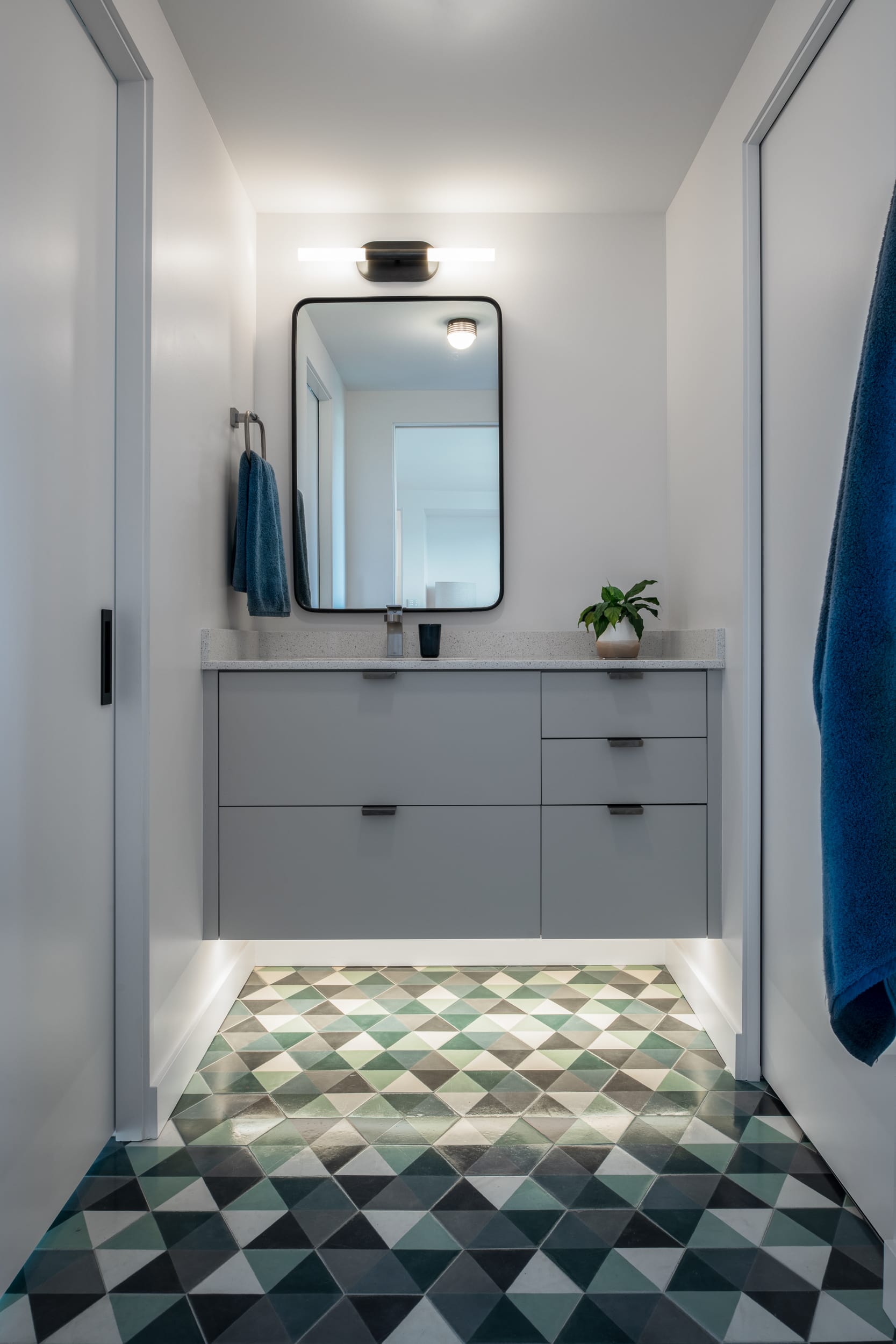 A bathroom with a green and blue tiled floor.