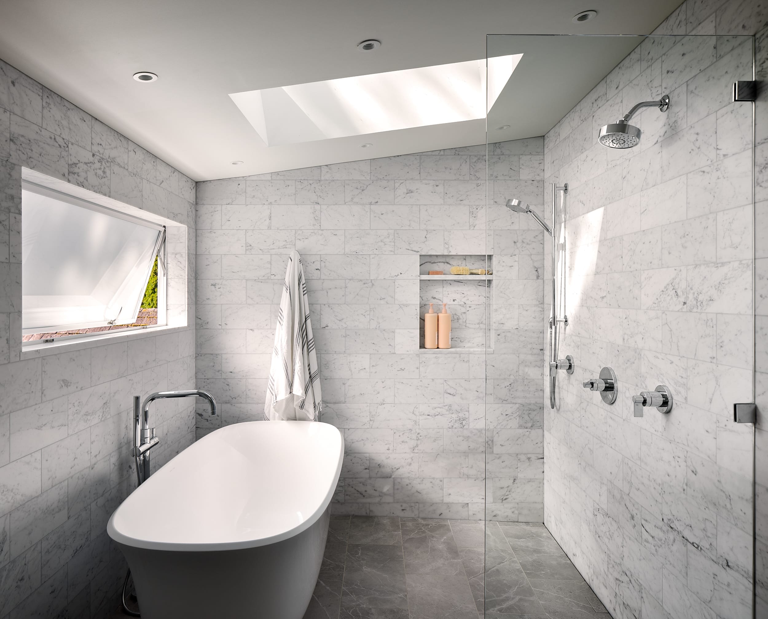 A modern home bathroom with a bathtub and a skylight.