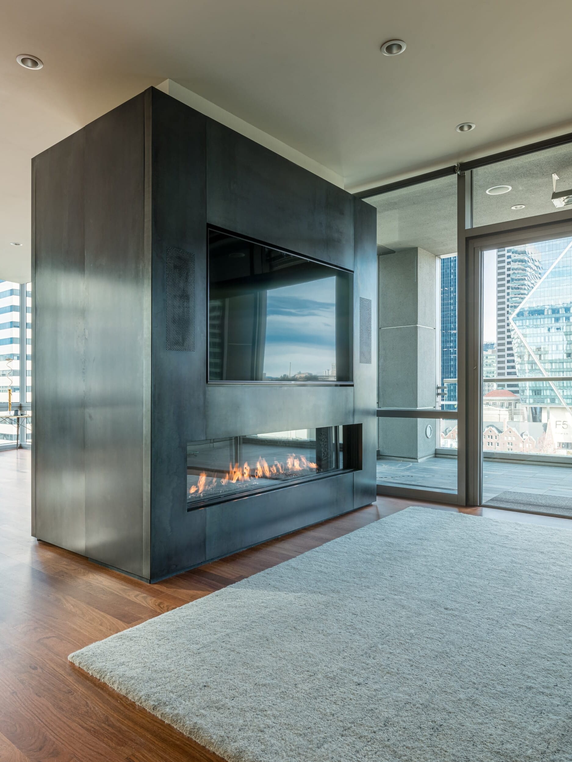 A living room with a fireplace and a view of the city.