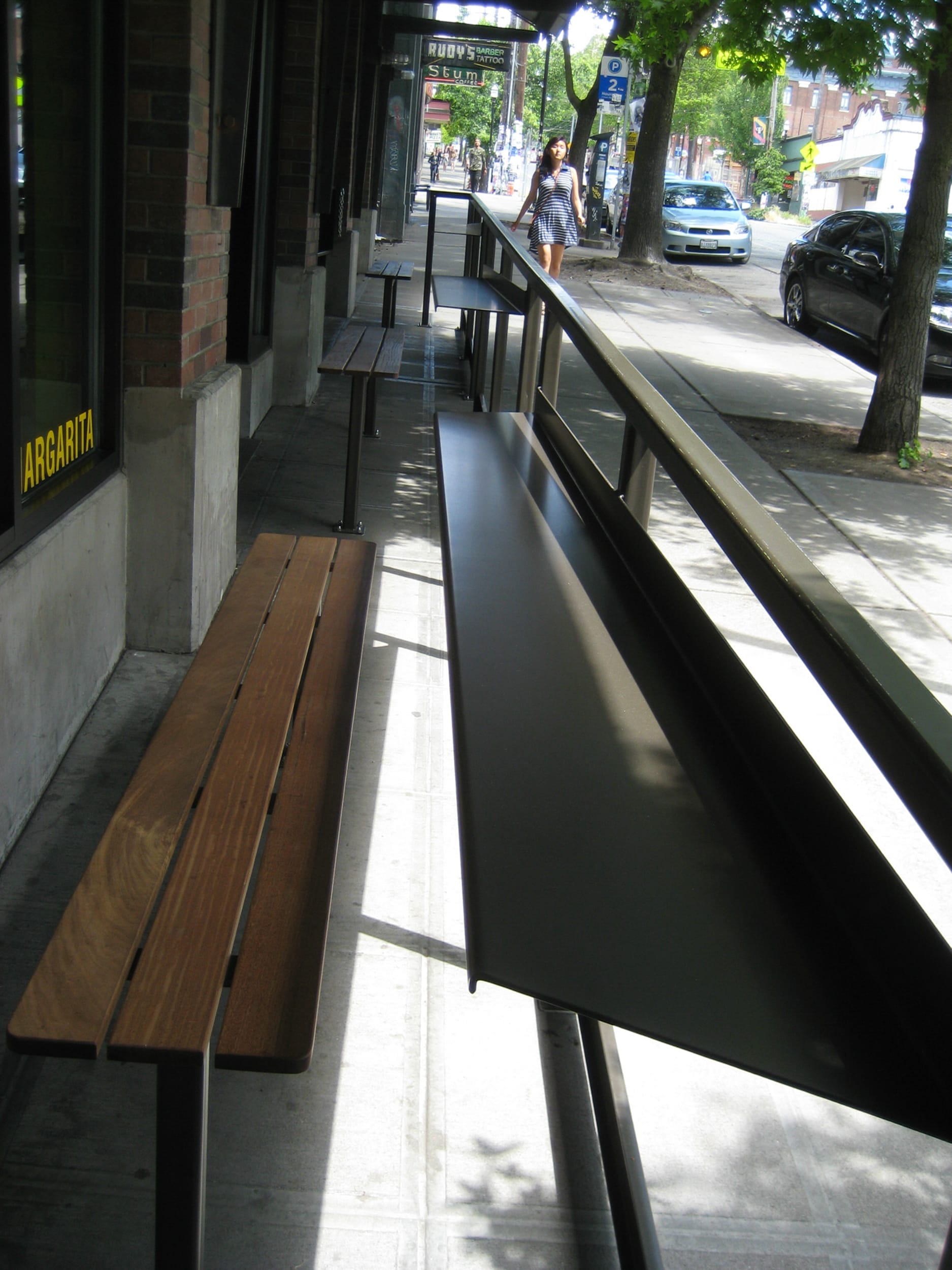 A wooden bench on a sidewalk.