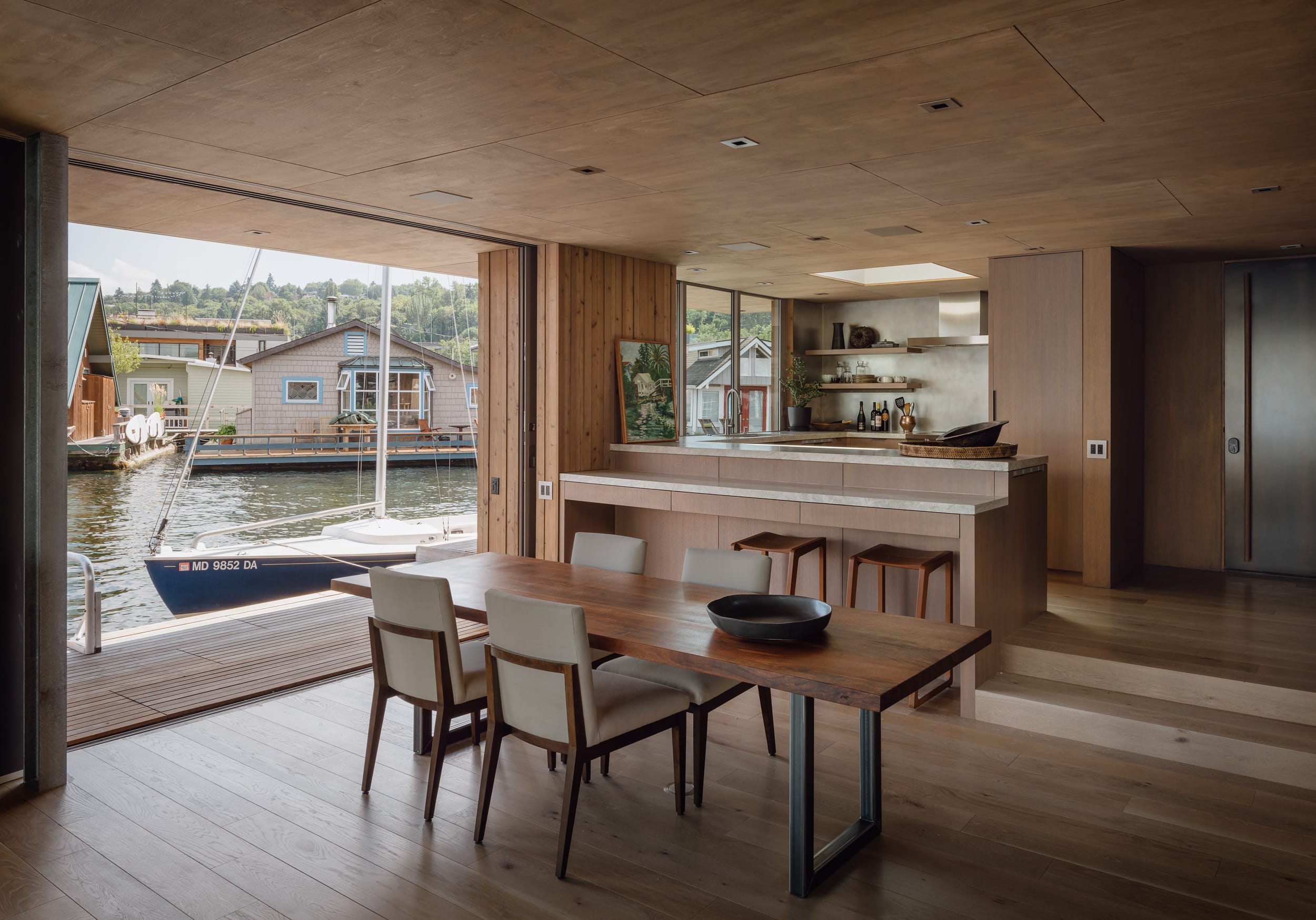 A modern home with a kitchen and dining room, offering a stunning view of the water.