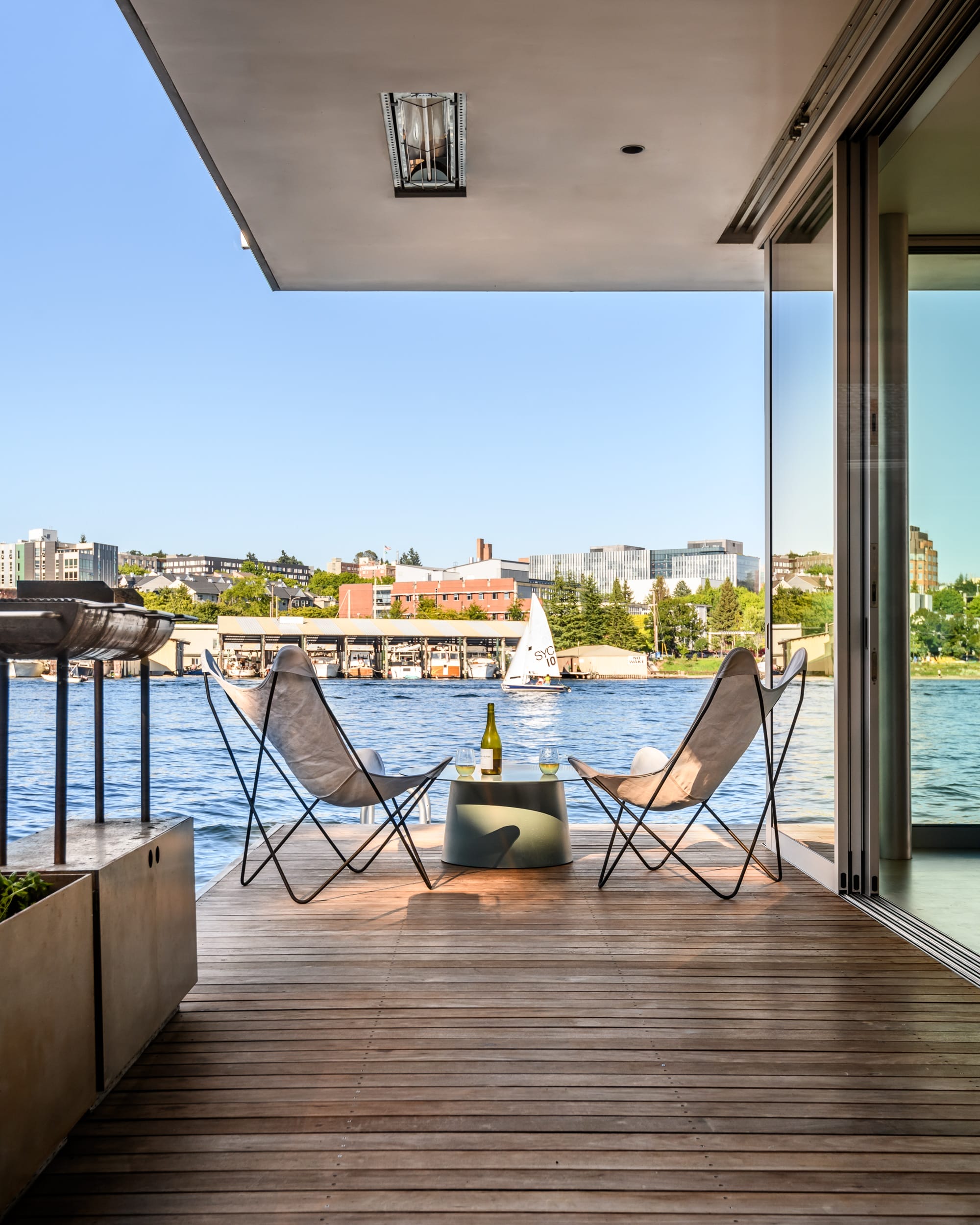A wooden deck with chairs and a view of the water.