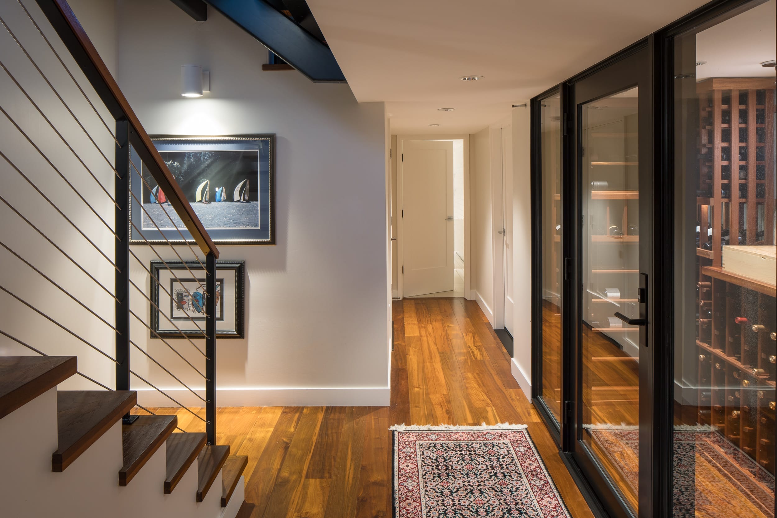 A modern hallway leading to a wine cellar in a floating home.