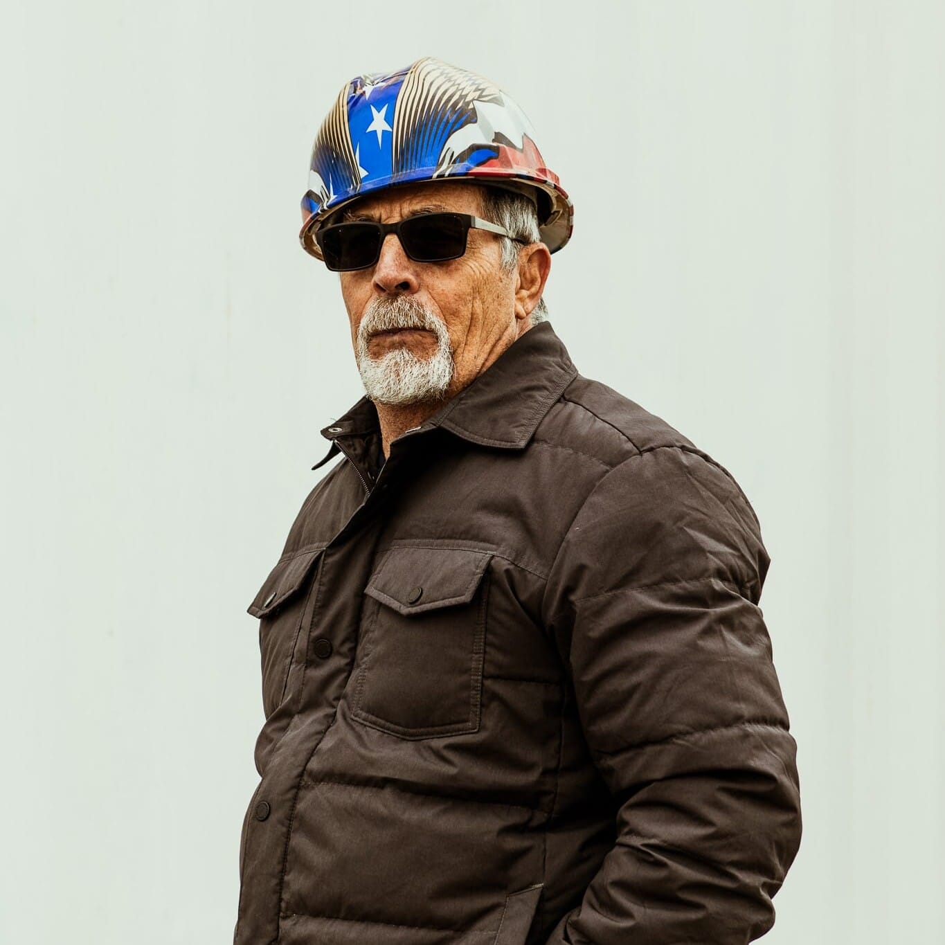 An older man, a Seattle Floating Homes contractor, wearing a hard hat and jacket.