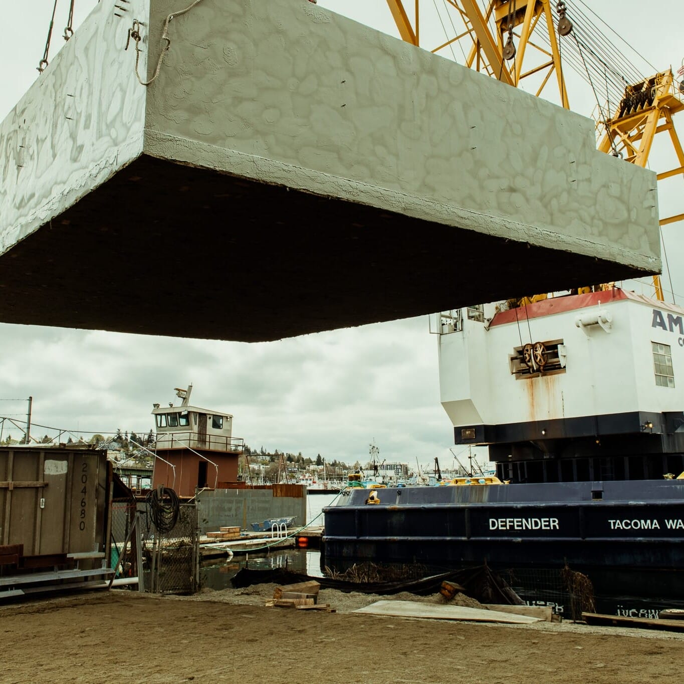 A Floating Homes contractor utilizing a crane to lift a large box.