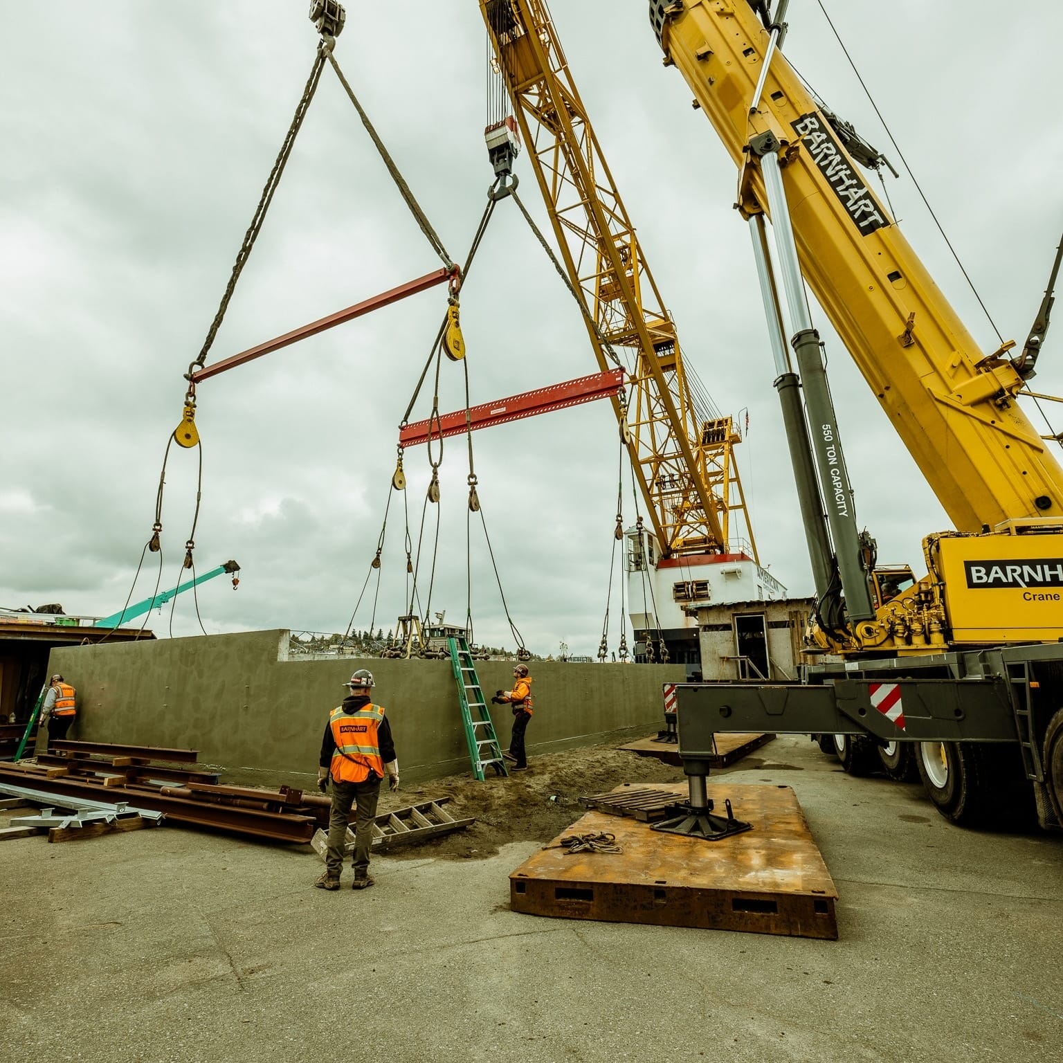 A Seattle Floating Homes contractor is using a crane to lift a large piece of concrete.