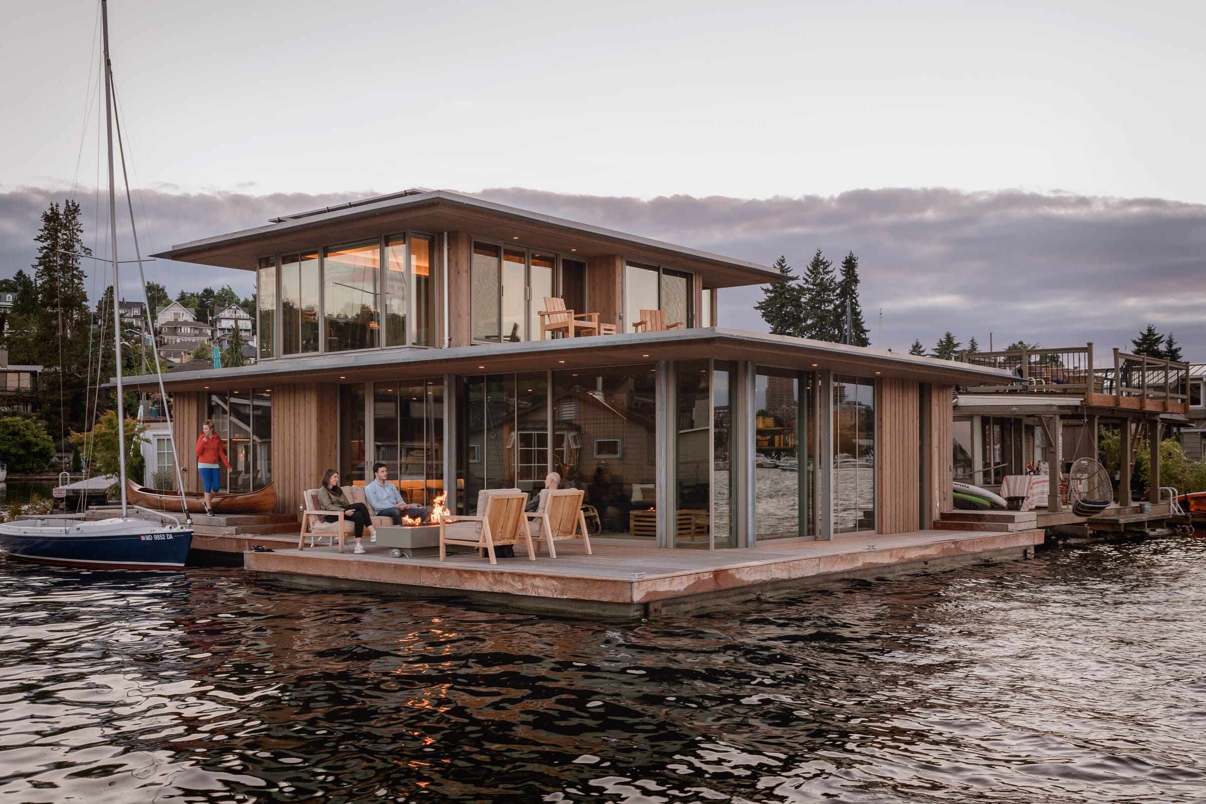 A modern floating home crafted by a skilled carpenter on a body of water.