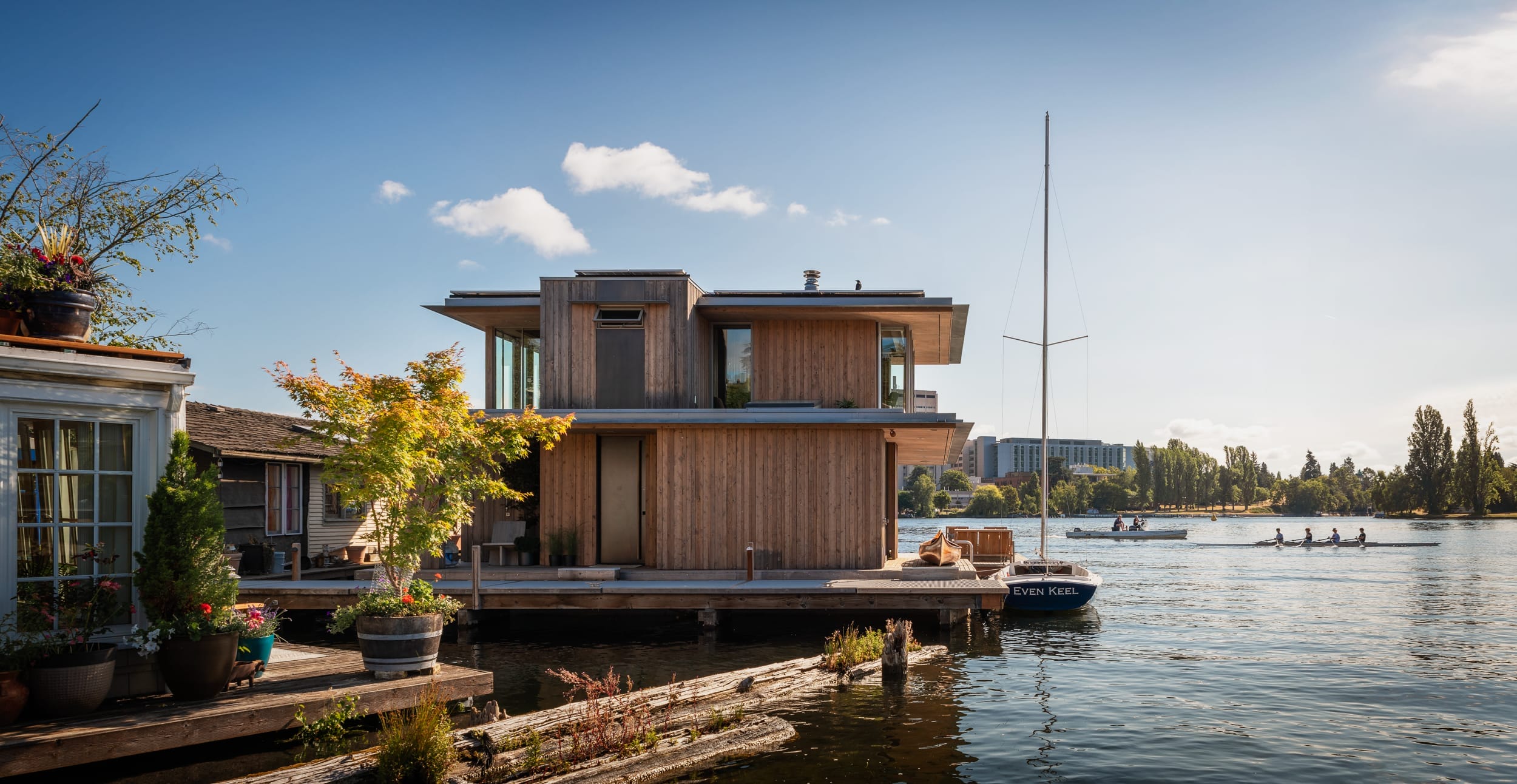 A modern home on a dock in a body of water built by a carpenter.