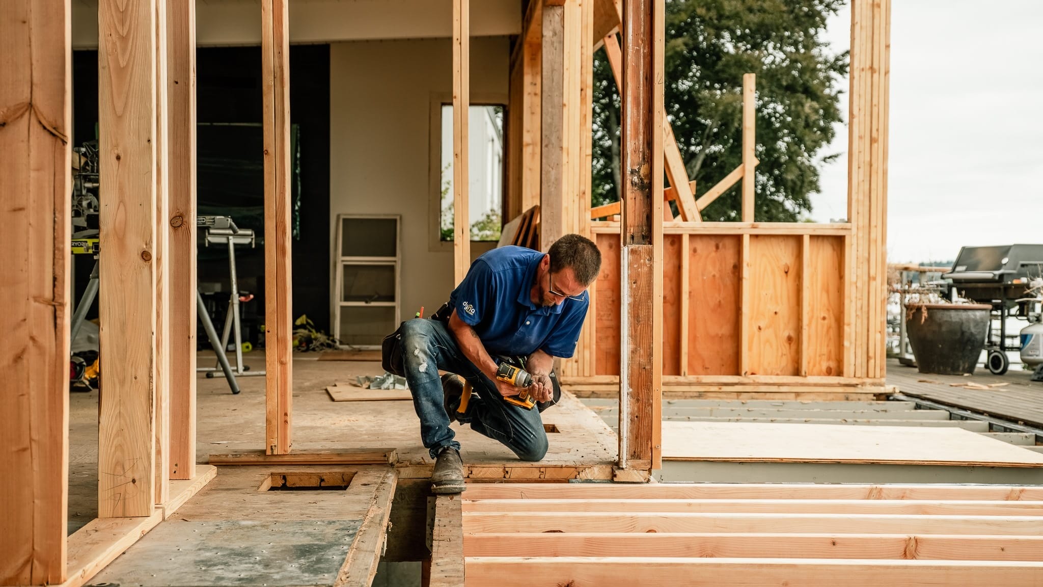 A carpenter is working on framing for a modern home.