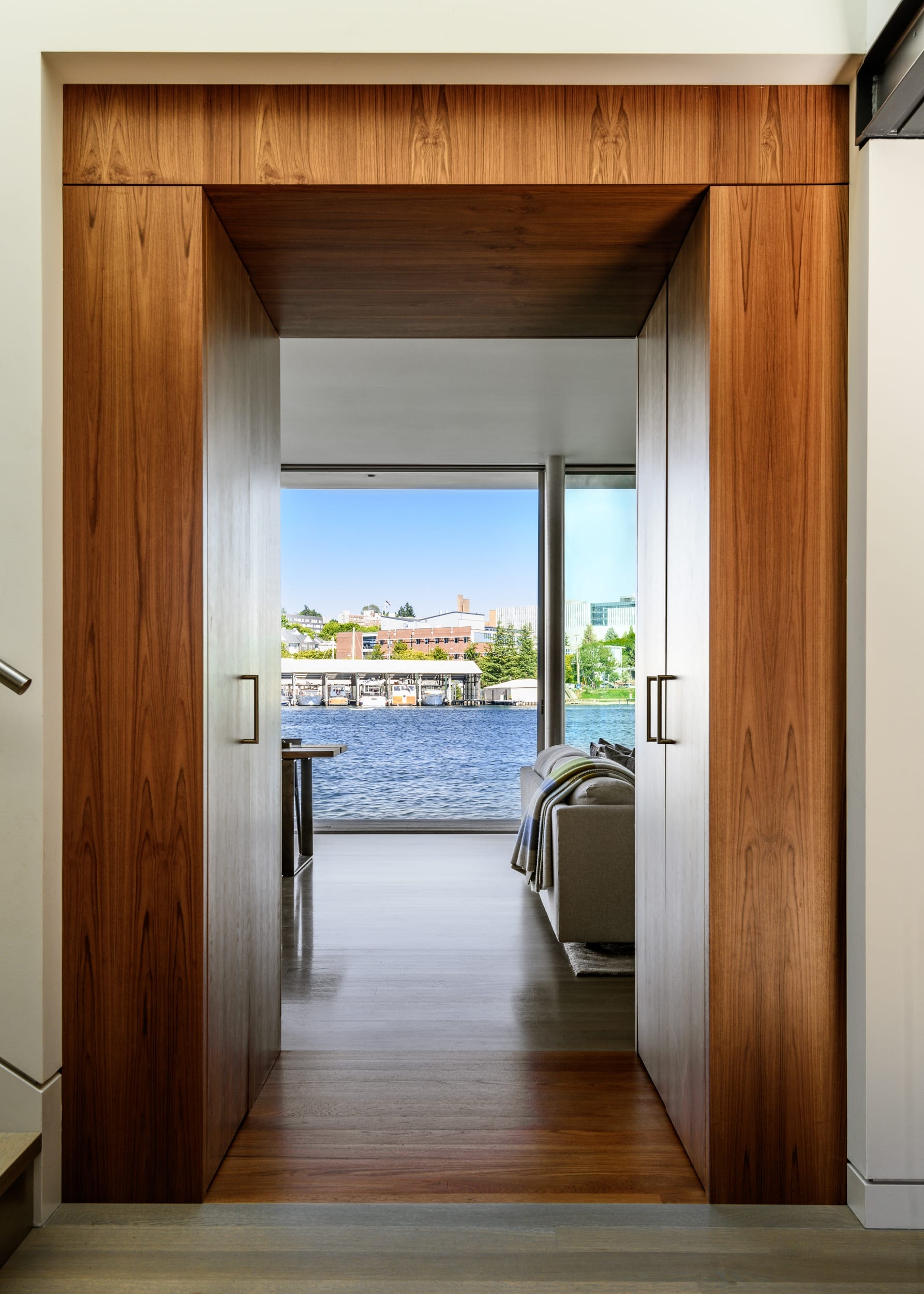 A wooden door leading to a room with a view of the water.