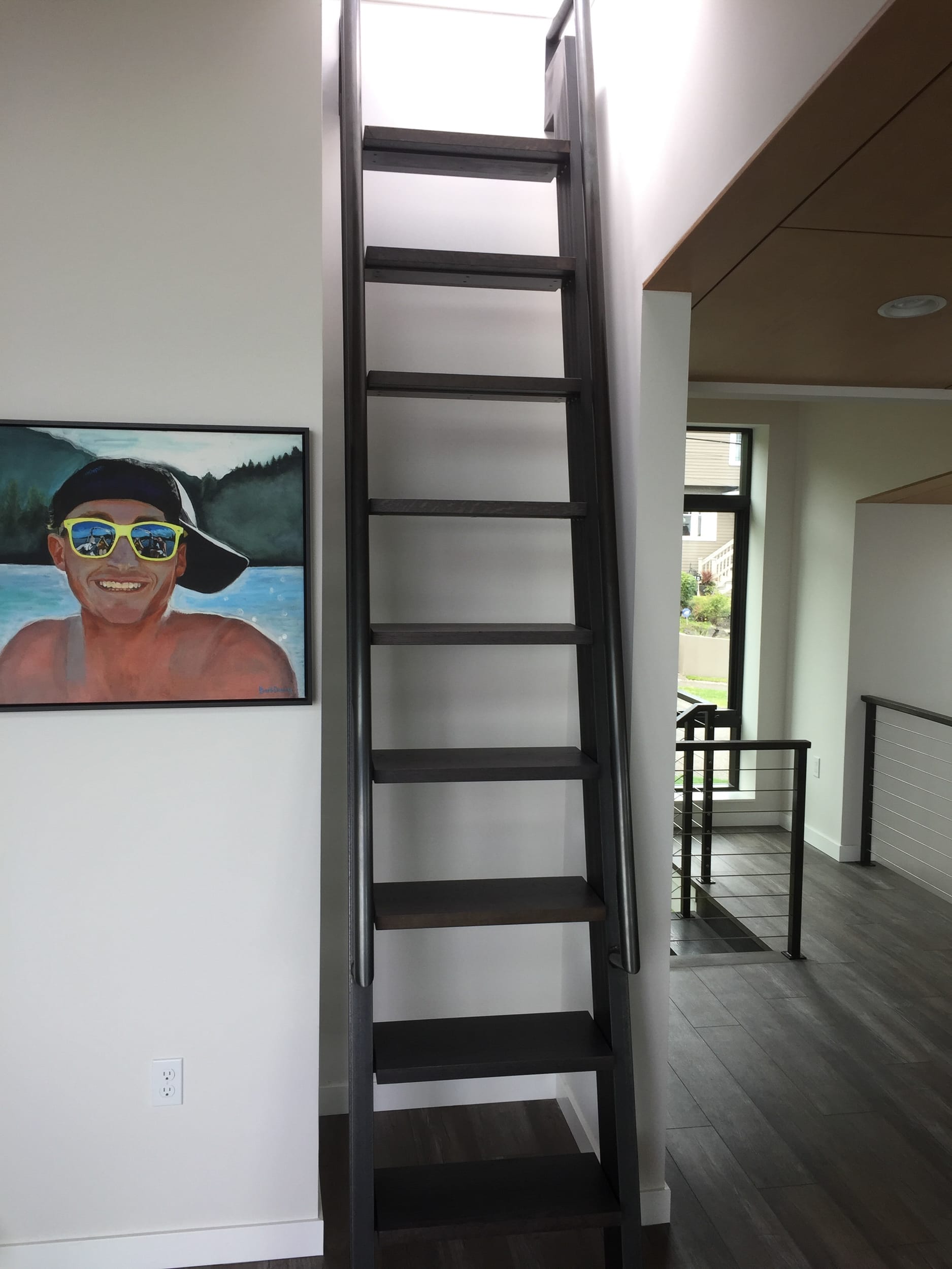 A ladder leading up to a painting of a man in sunglasses.