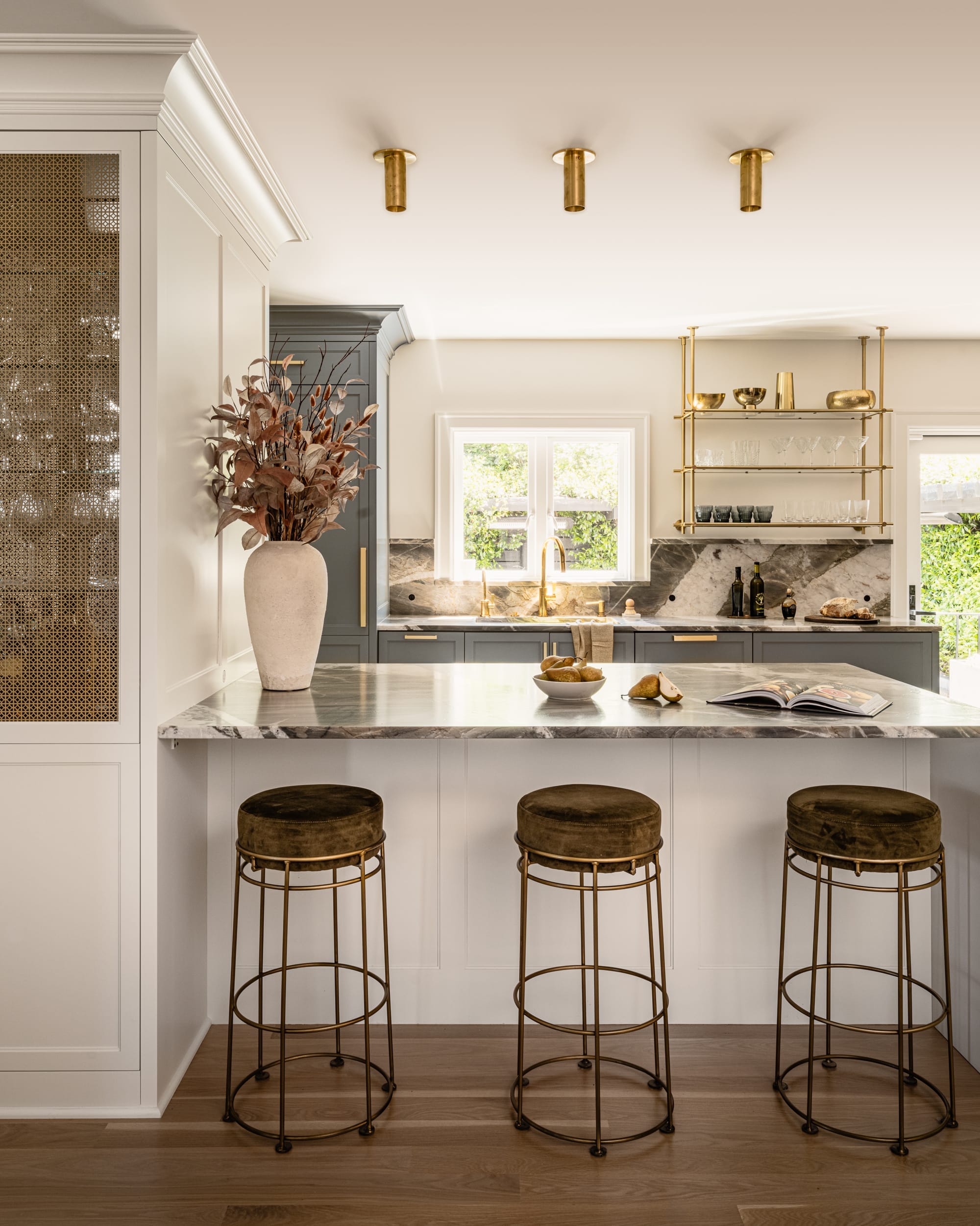 A kitchen with a marble countertop and stools.
