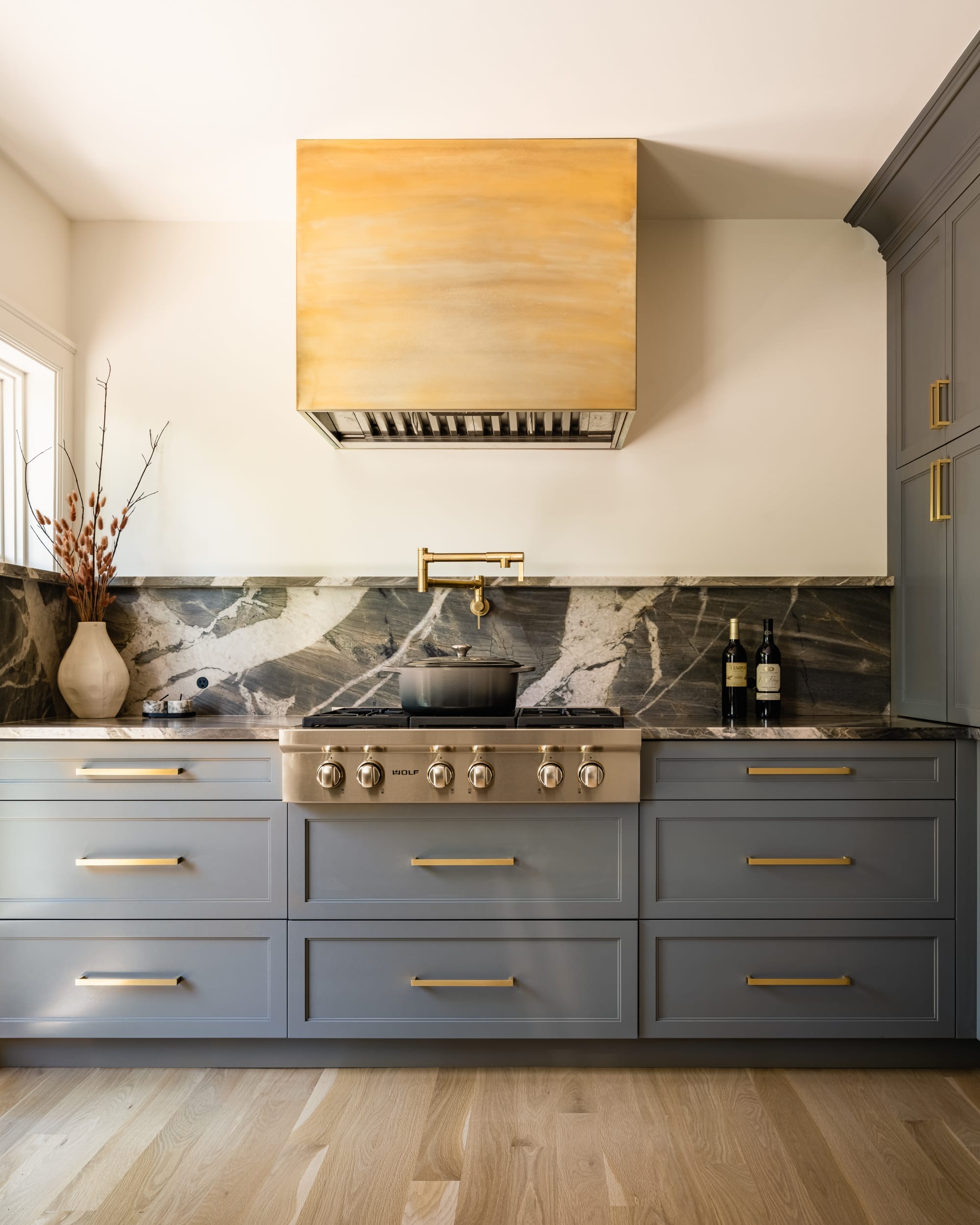 A kitchen with blue cabinets and gold appliances.