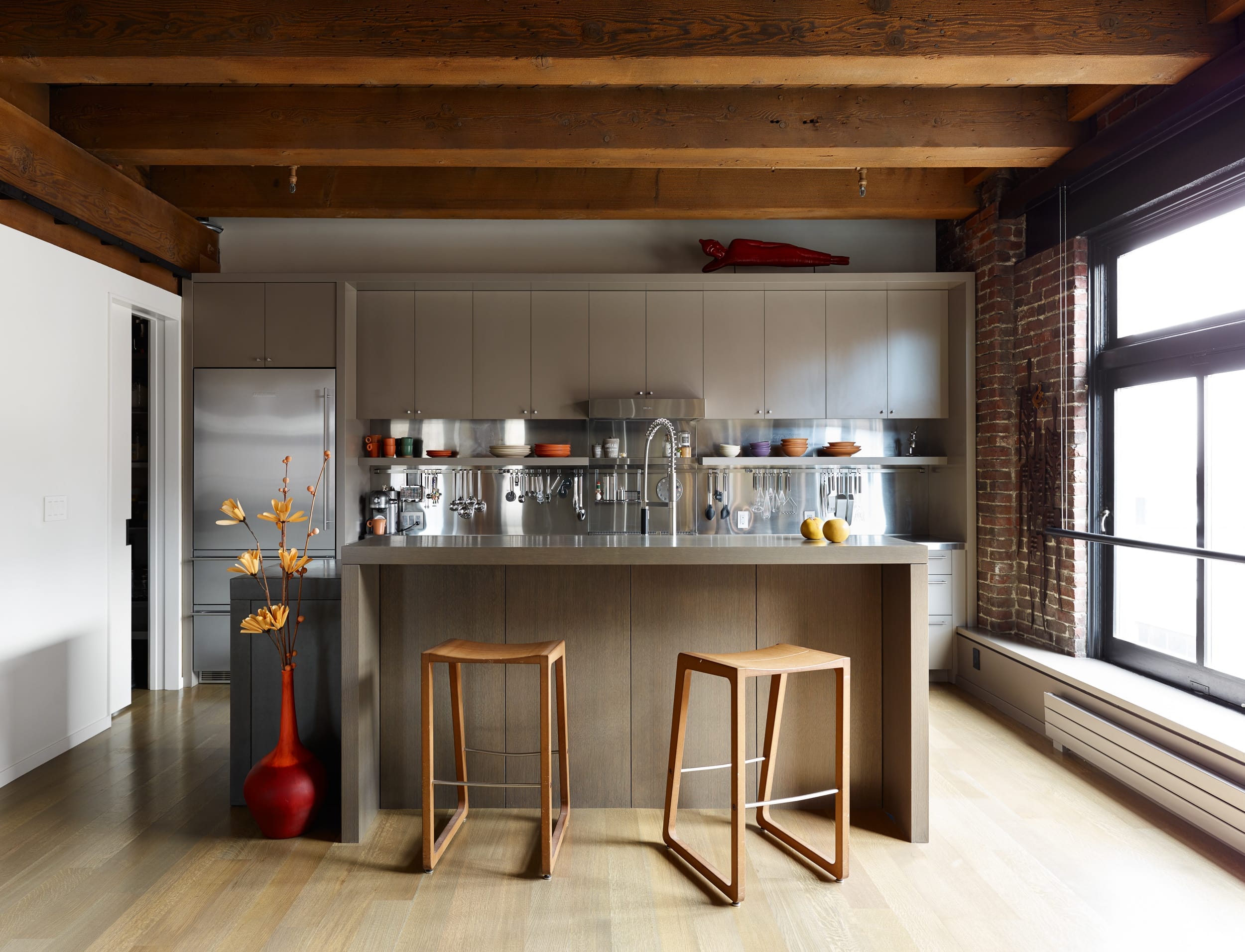 A kitchen with wooden beams and stools.