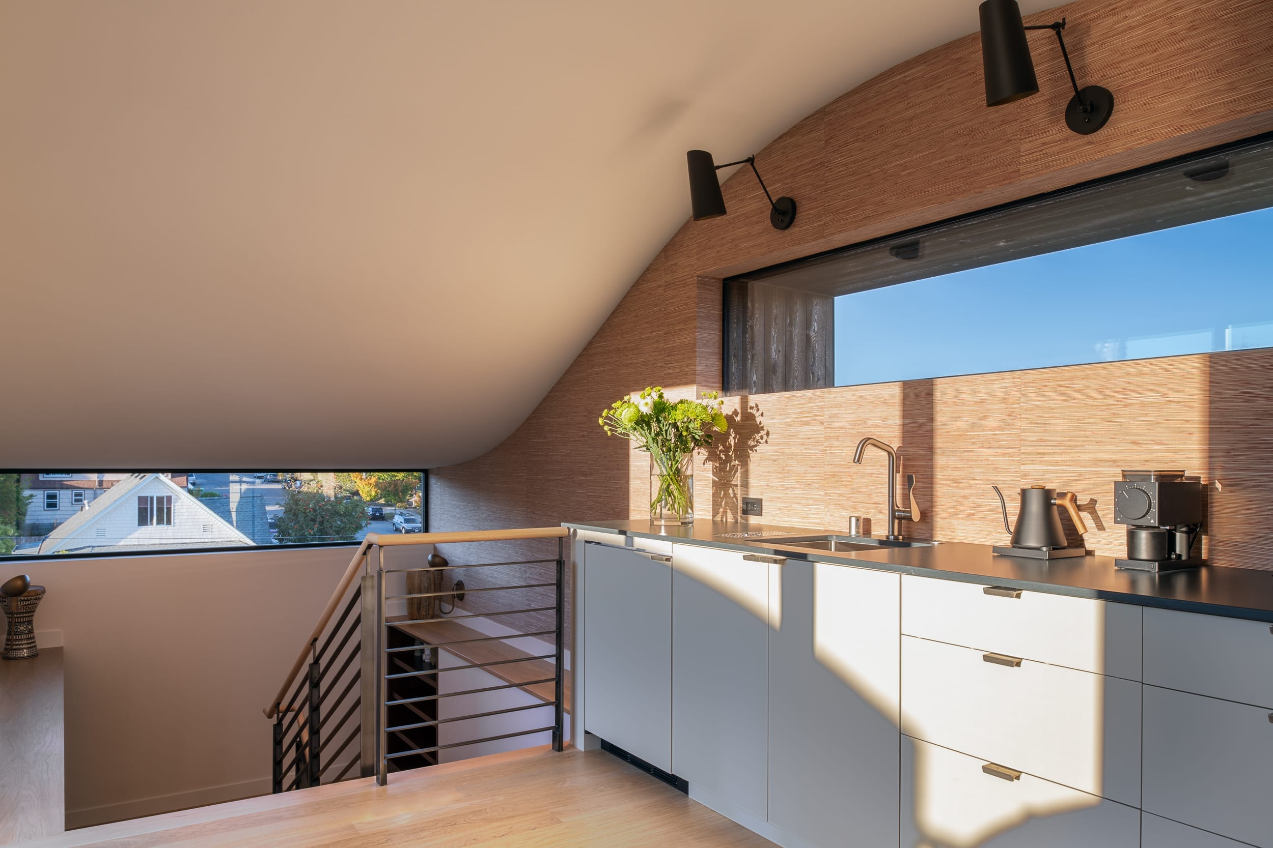 A kitchen in an attic with a view of the city.