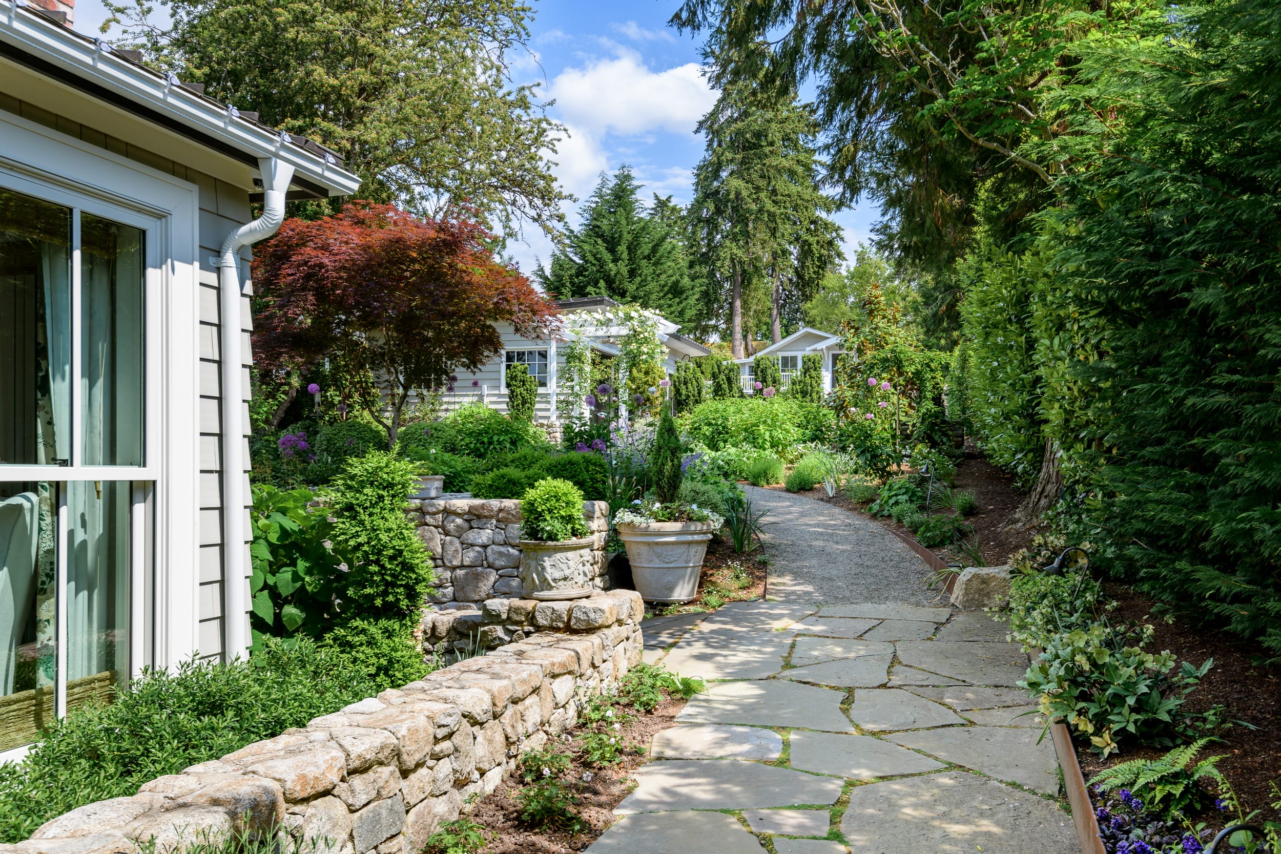 A stone walkway leads to a garden.