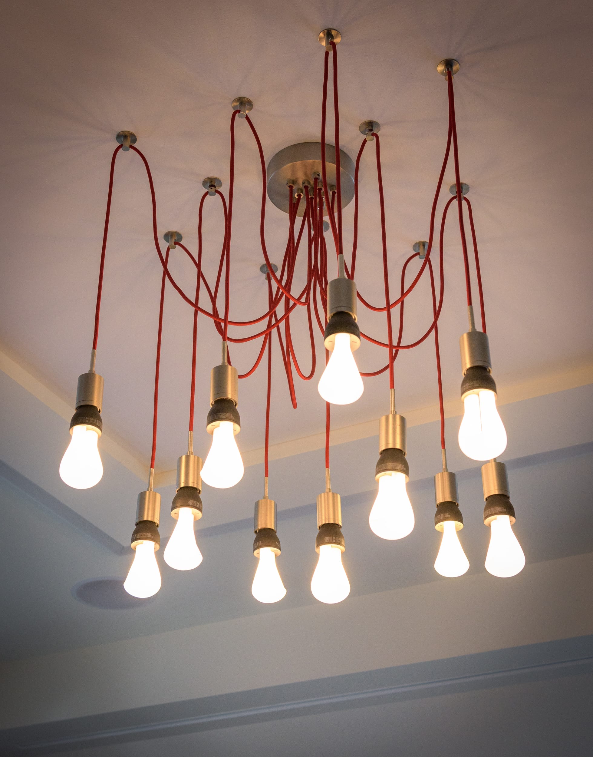 A room with many light bulbs hanging from the ceiling in a floating home.
