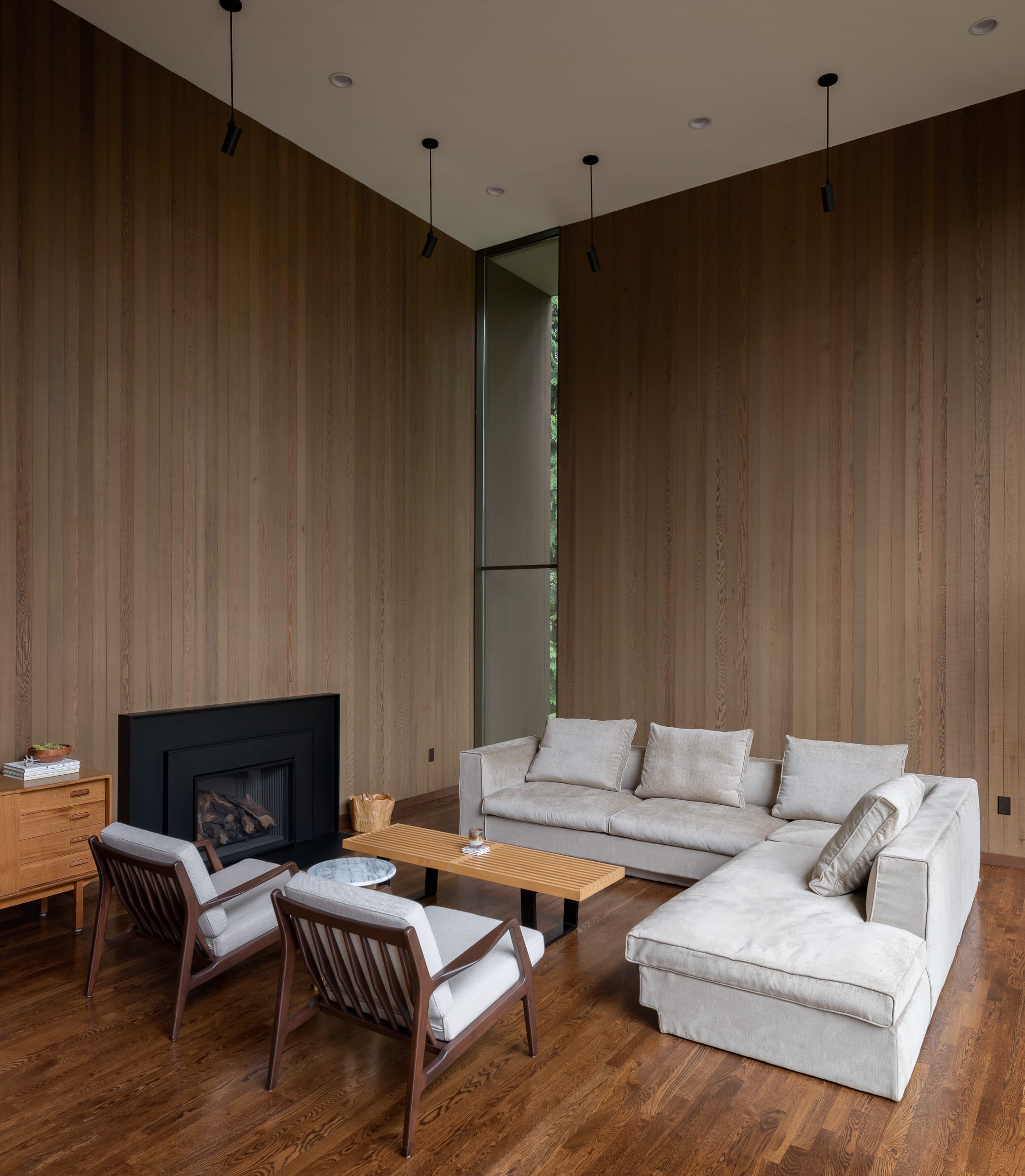 A living room with wooden walls and a fireplace.