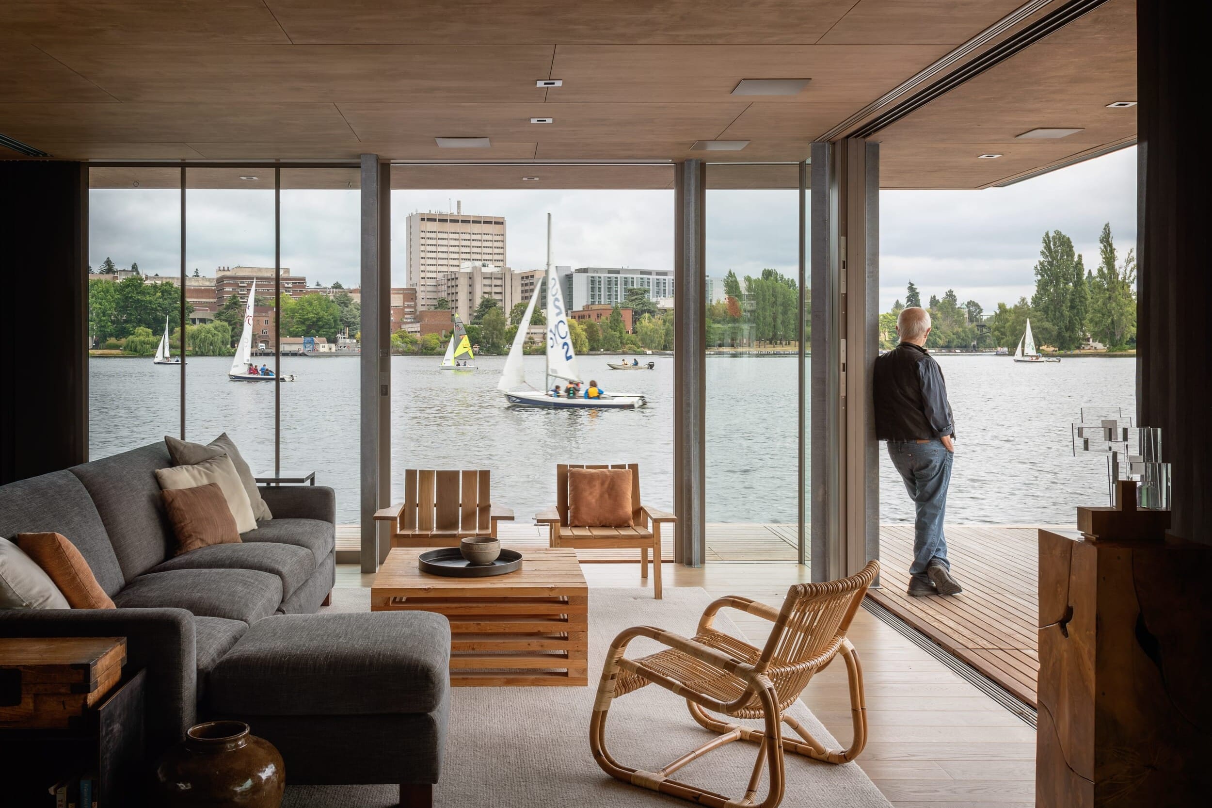 A floating home with large windows overlooking a body of water.