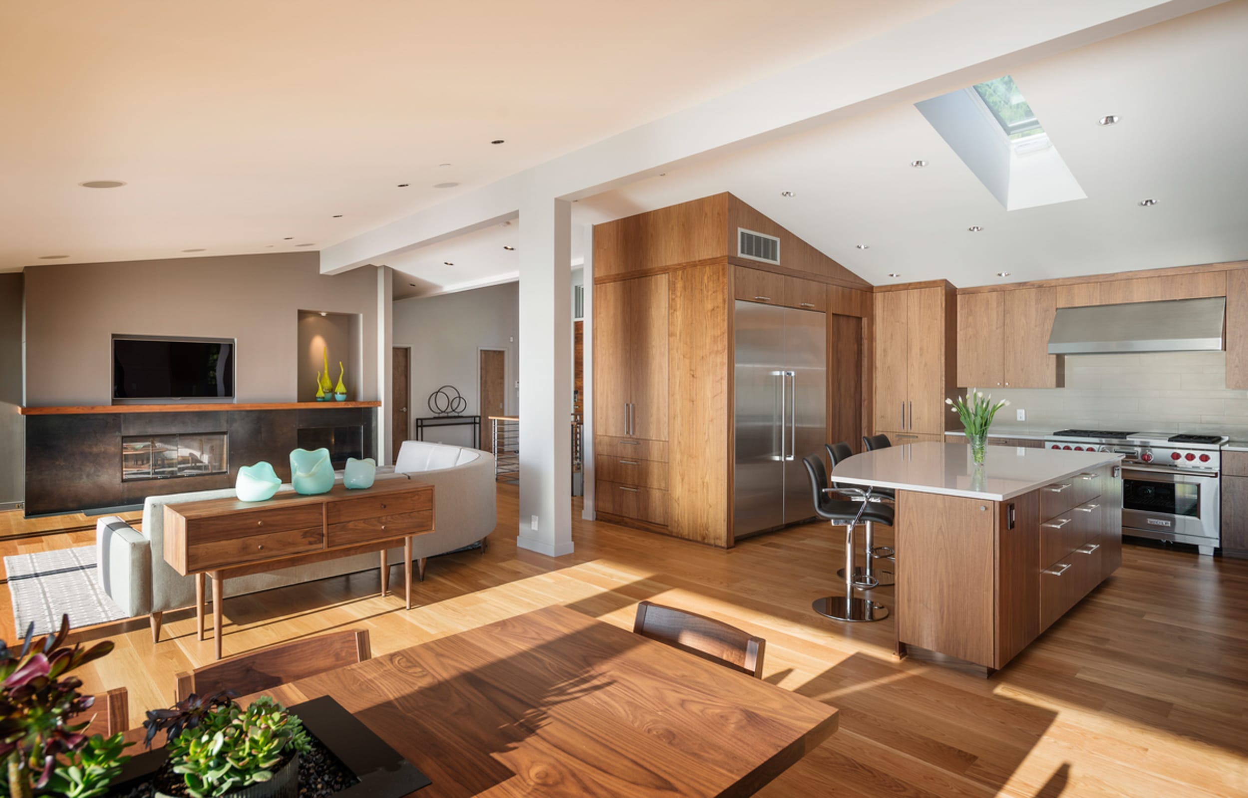 A modern kitchen with wood cabinets and a skylight.