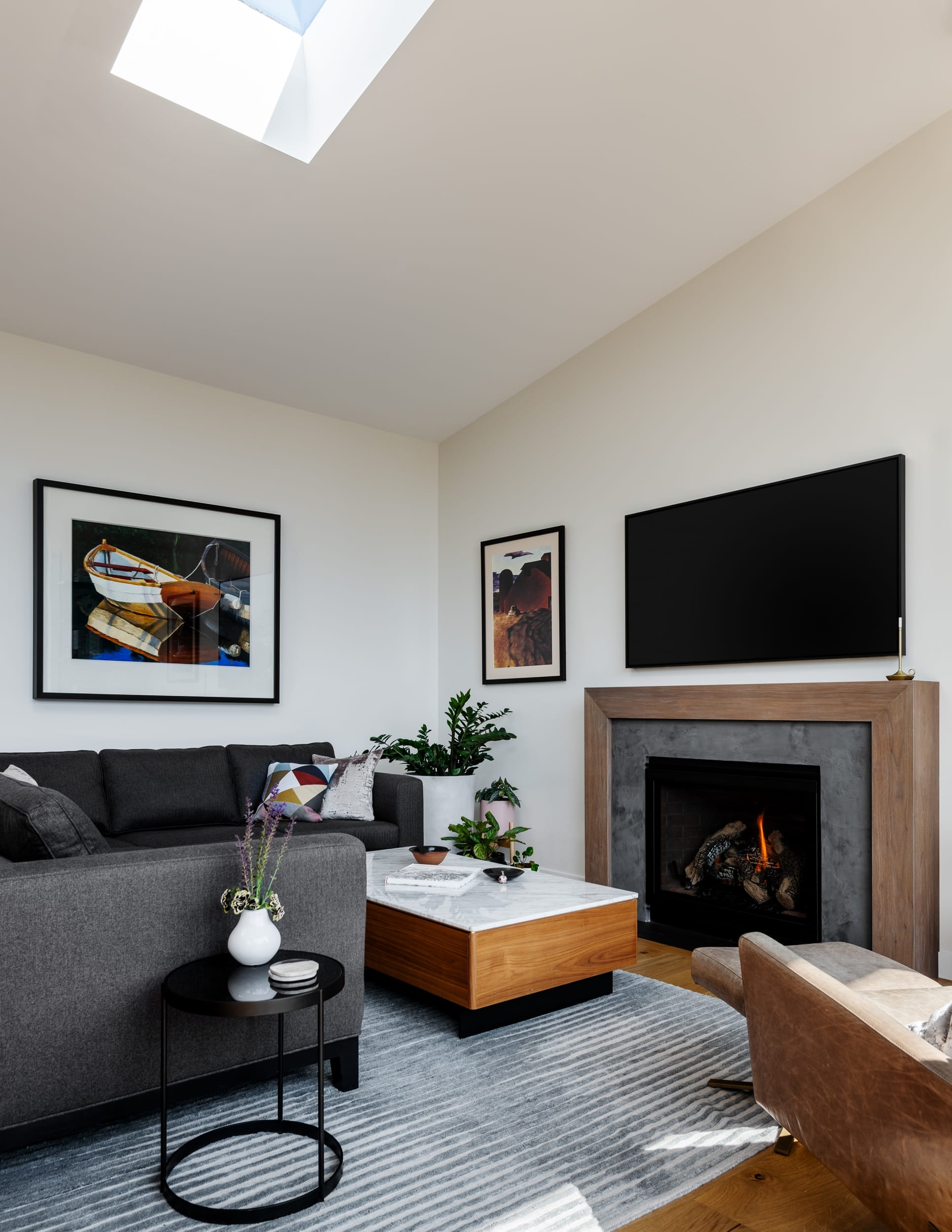 A modern living room with a skylight over the fireplace.
