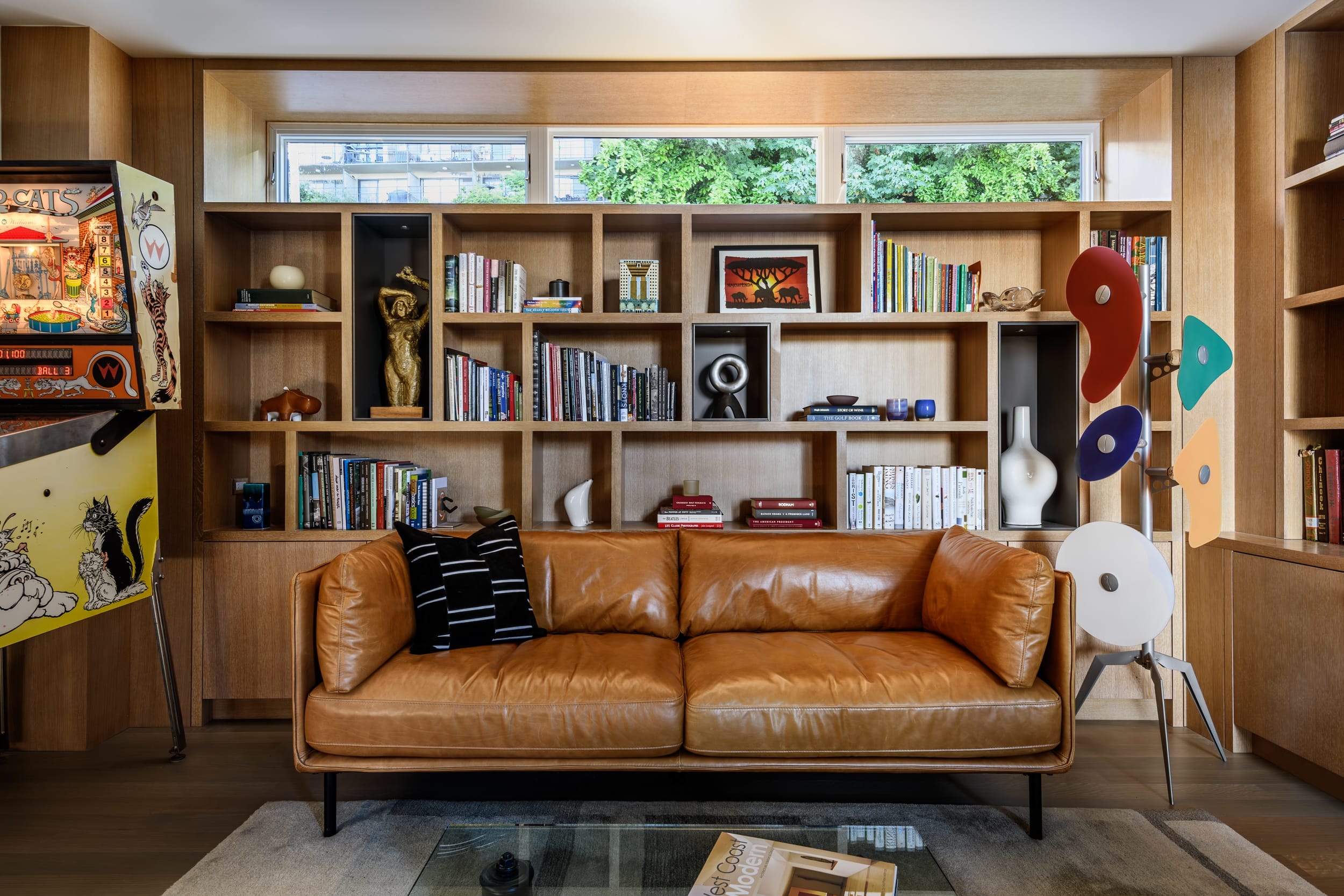 A living room with a leather couch and bookshelves.