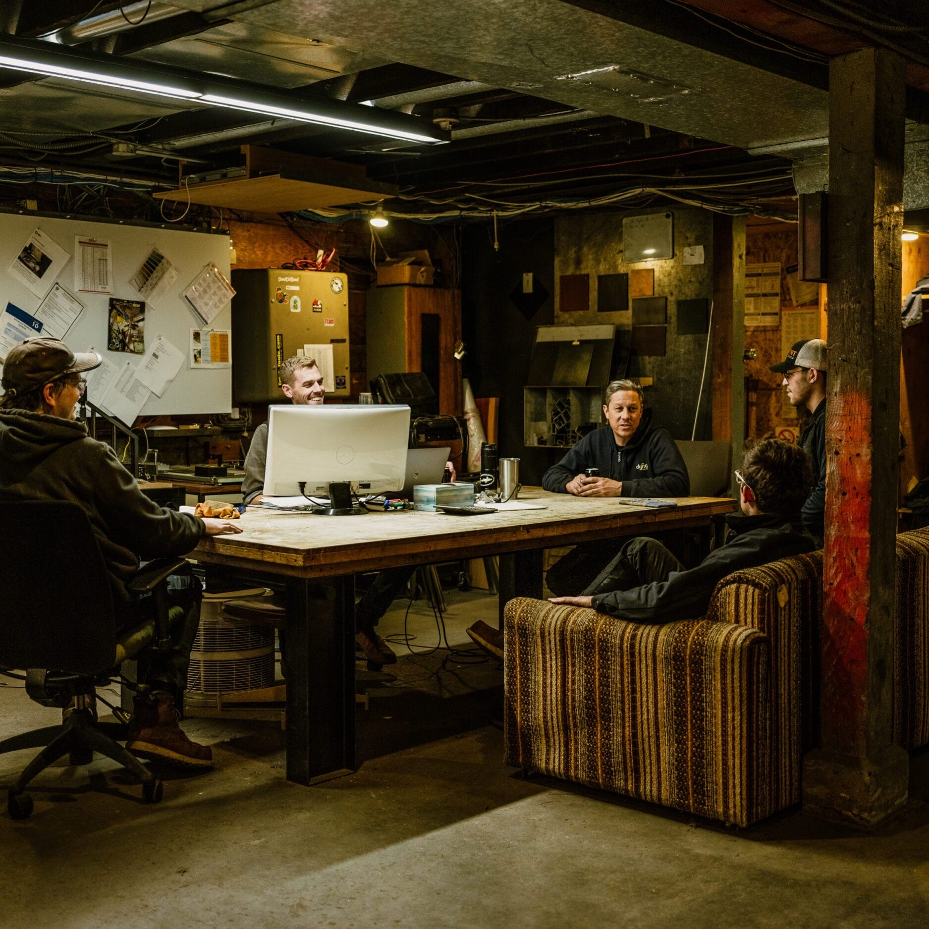 A group of people sitting around a table in Dyna Metal Shop Seattle.