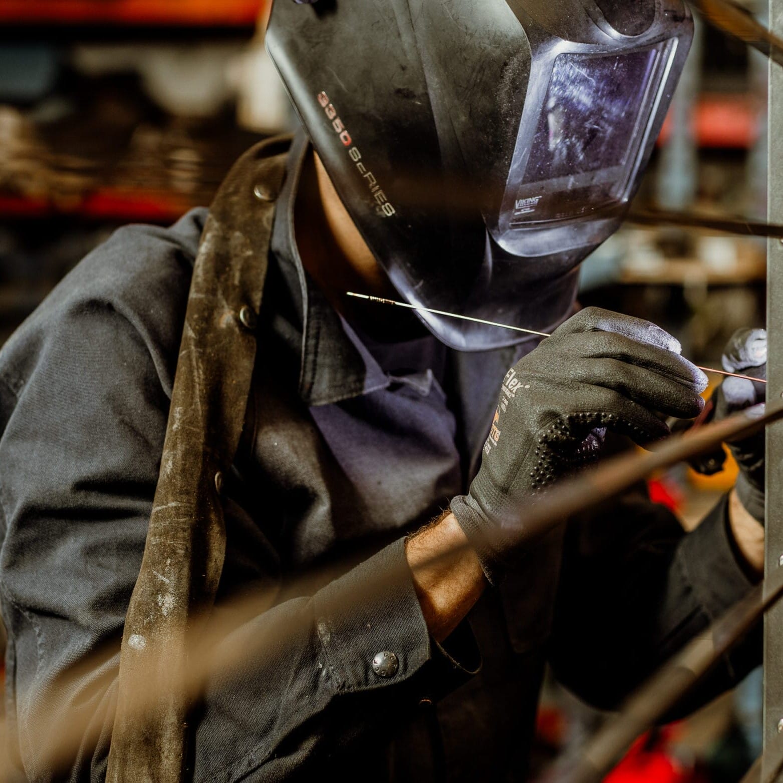 A welder working on a piece of metal at Dyna Metal Shop Seattle.