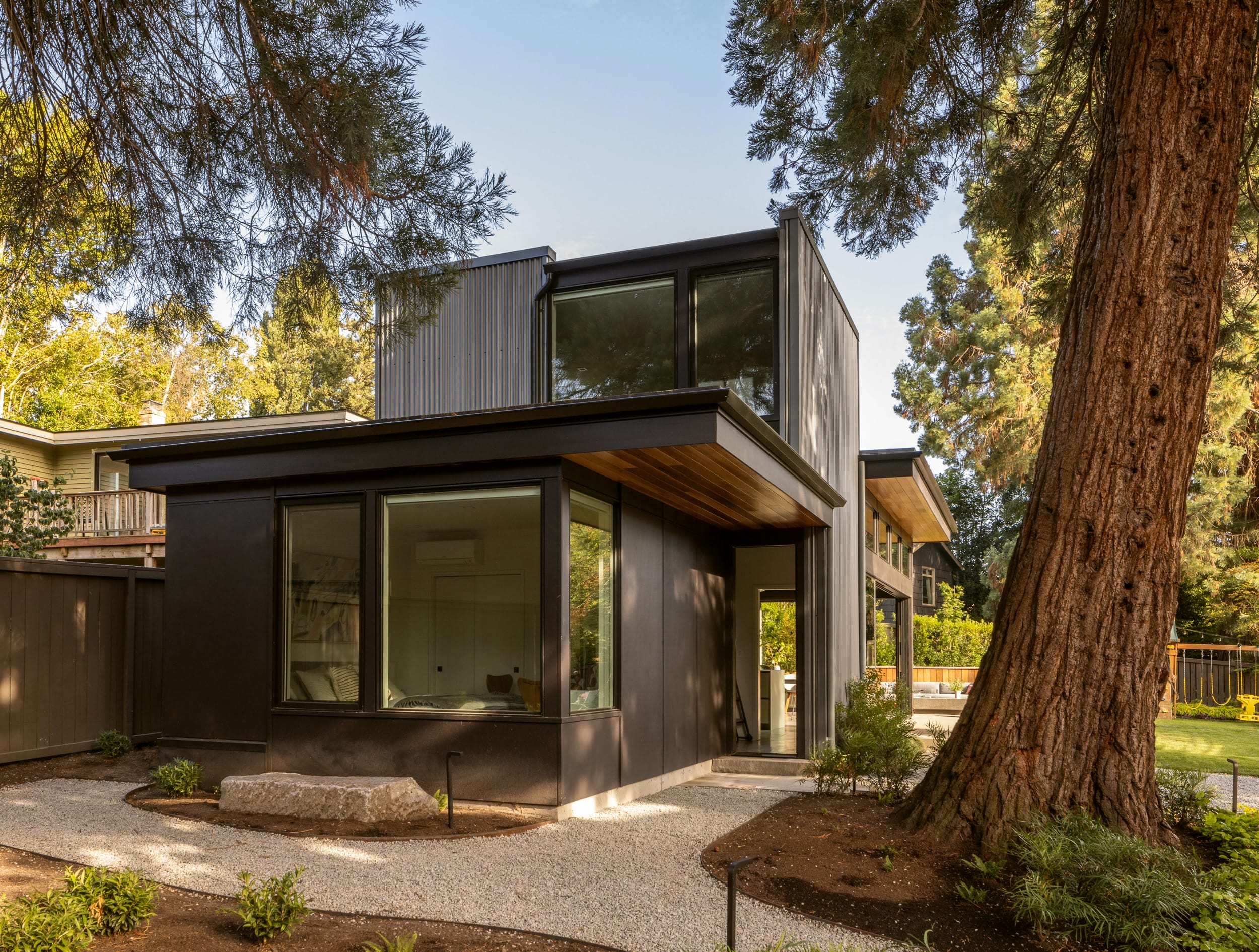 A carpenter-built modern home nestled in the woods, surrounded by trees.