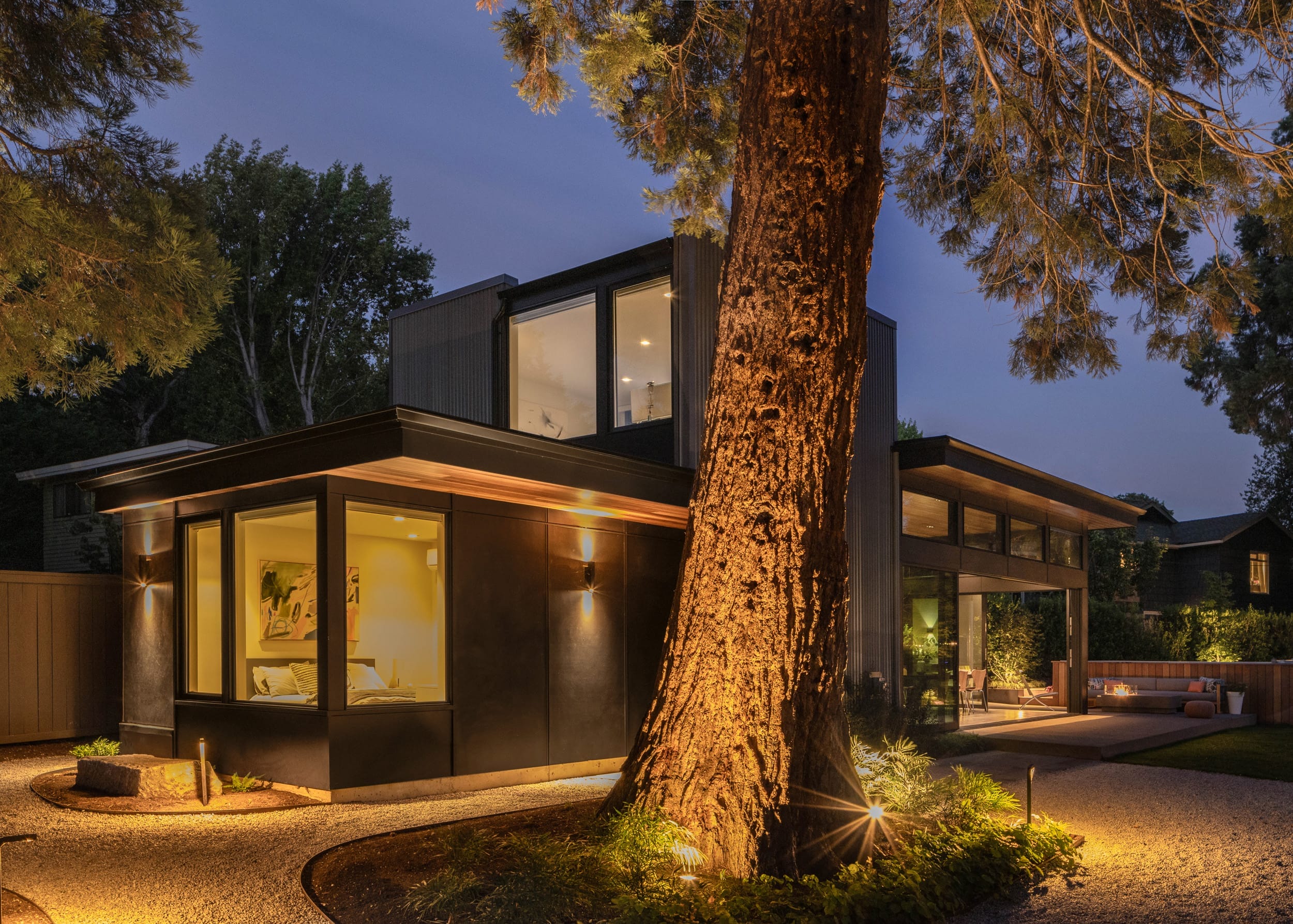 A beautifully designed modern home, built by skilled carpenters, stands resplendent as its façade radiates with enchanting nighttime illumination.