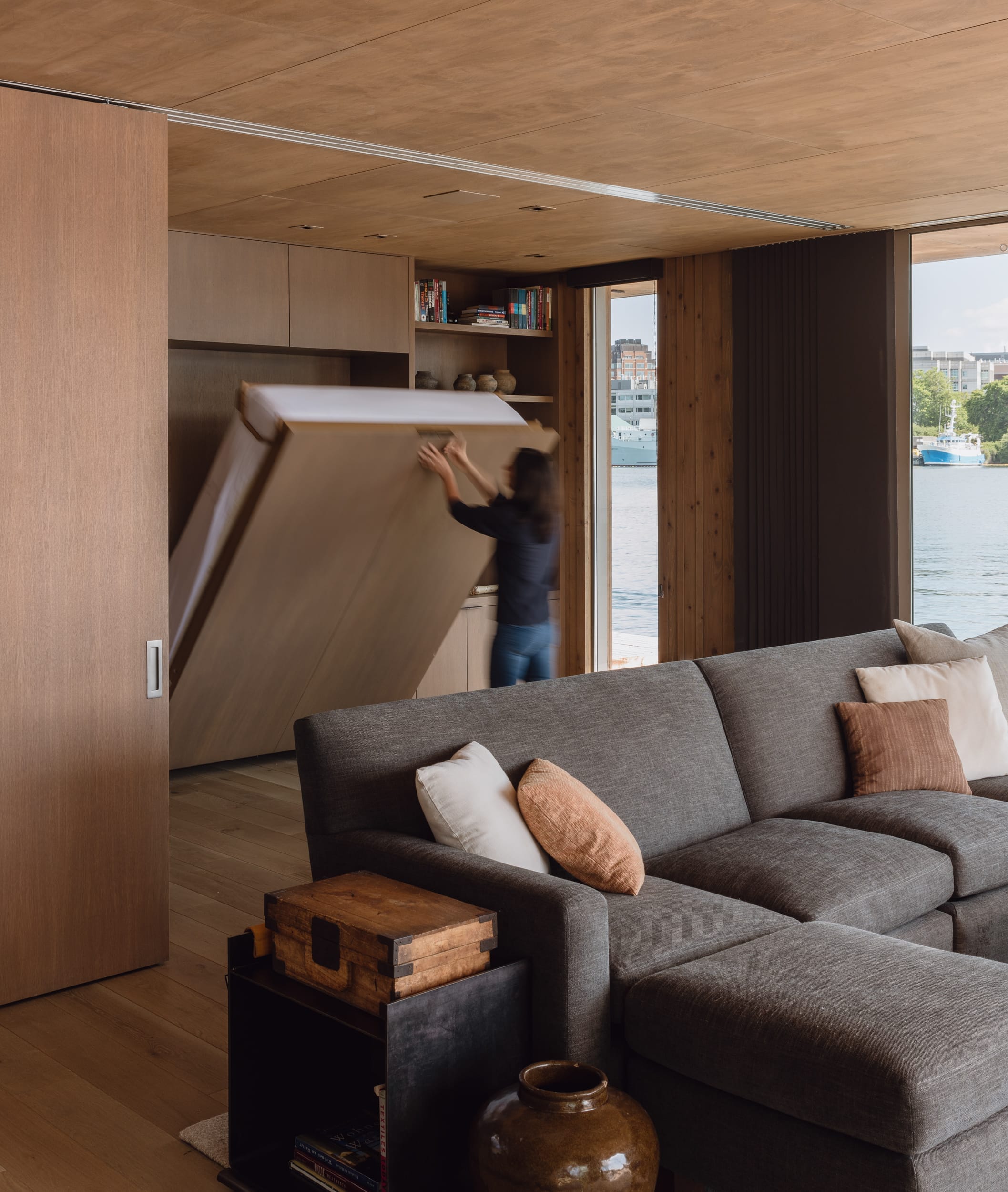A carpenter is moving a couch into a floating home.