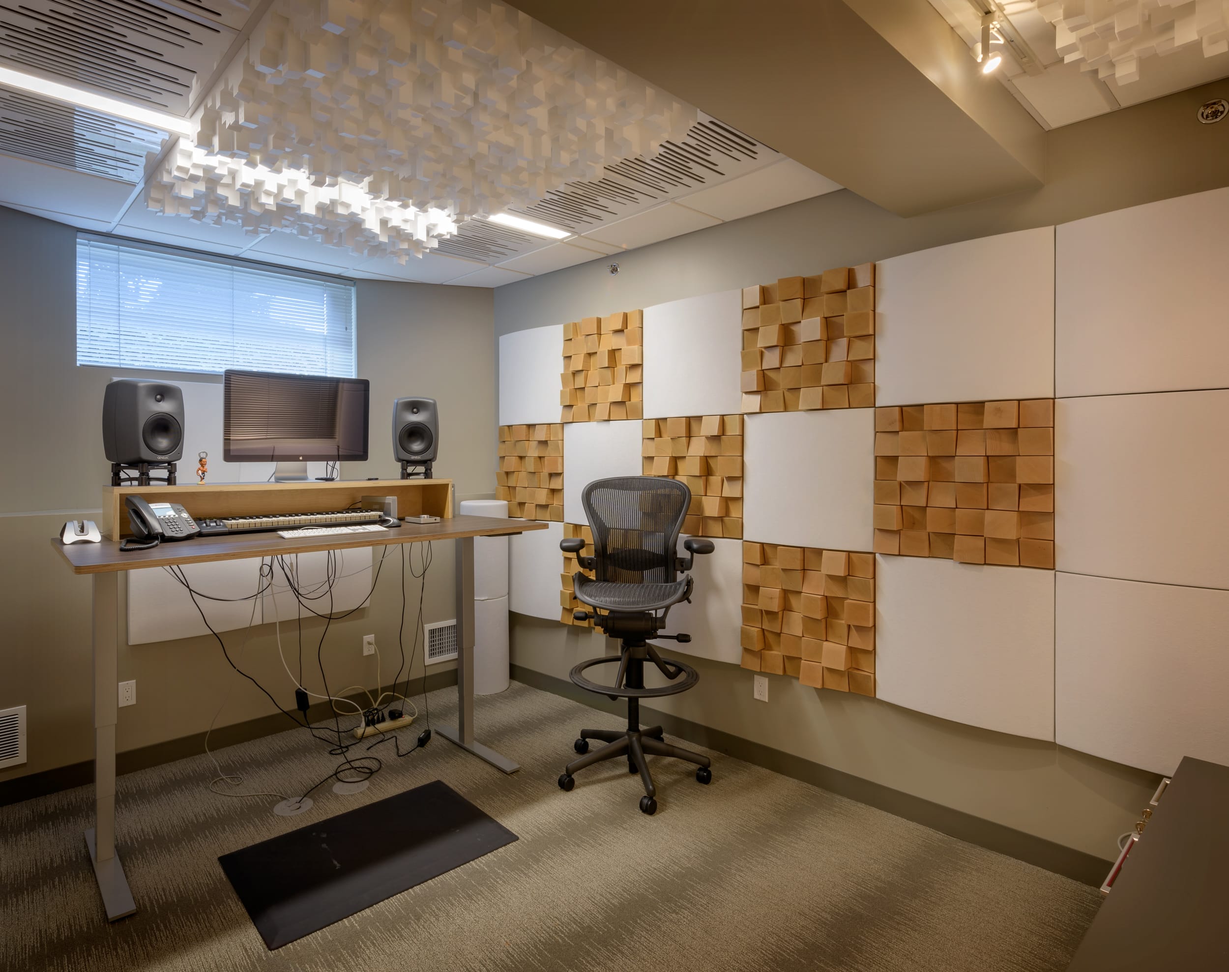 A modern recording studio with a desk and chairs in a home building.