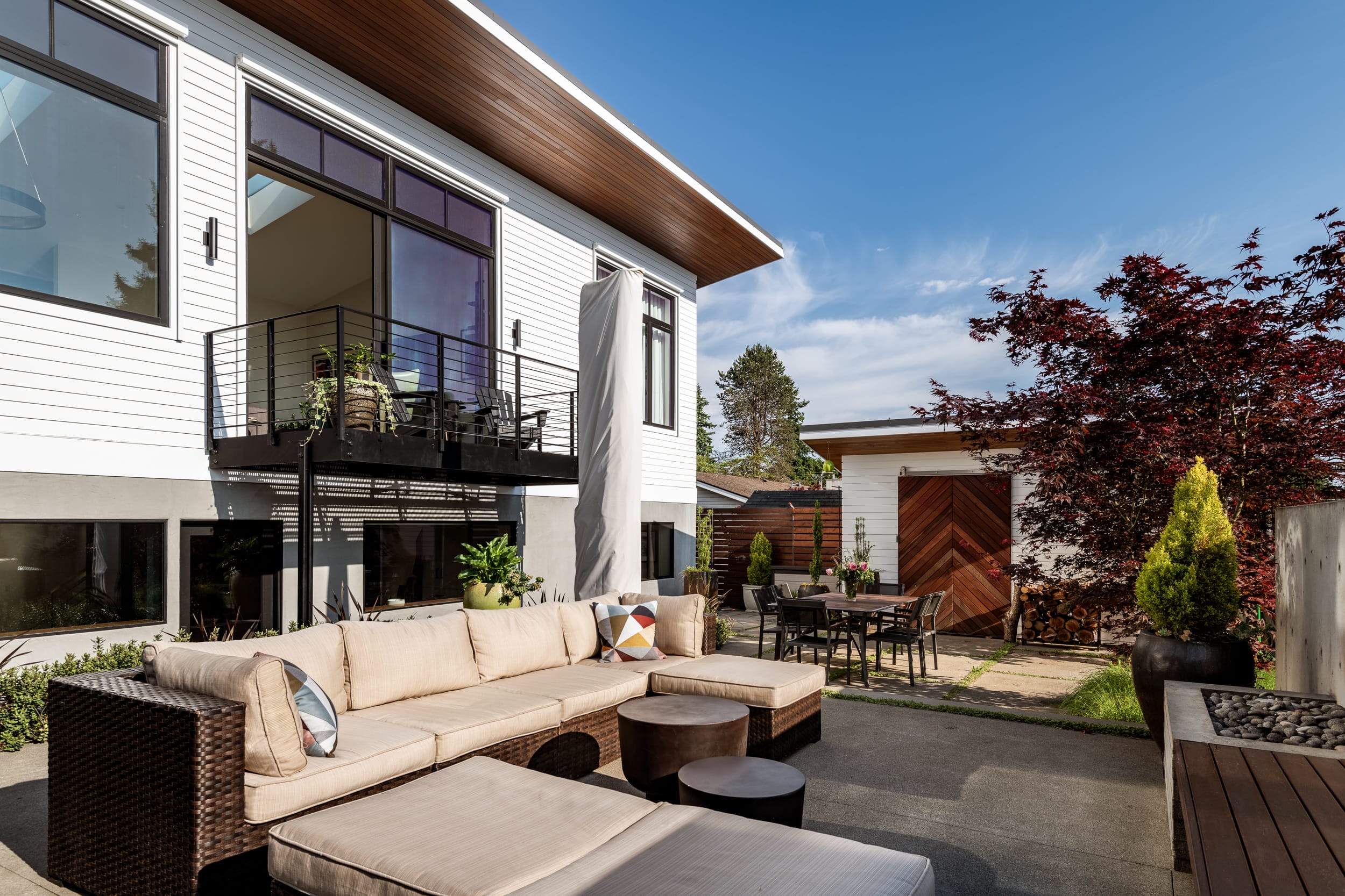 A modern home with a patio and outdoor furniture.