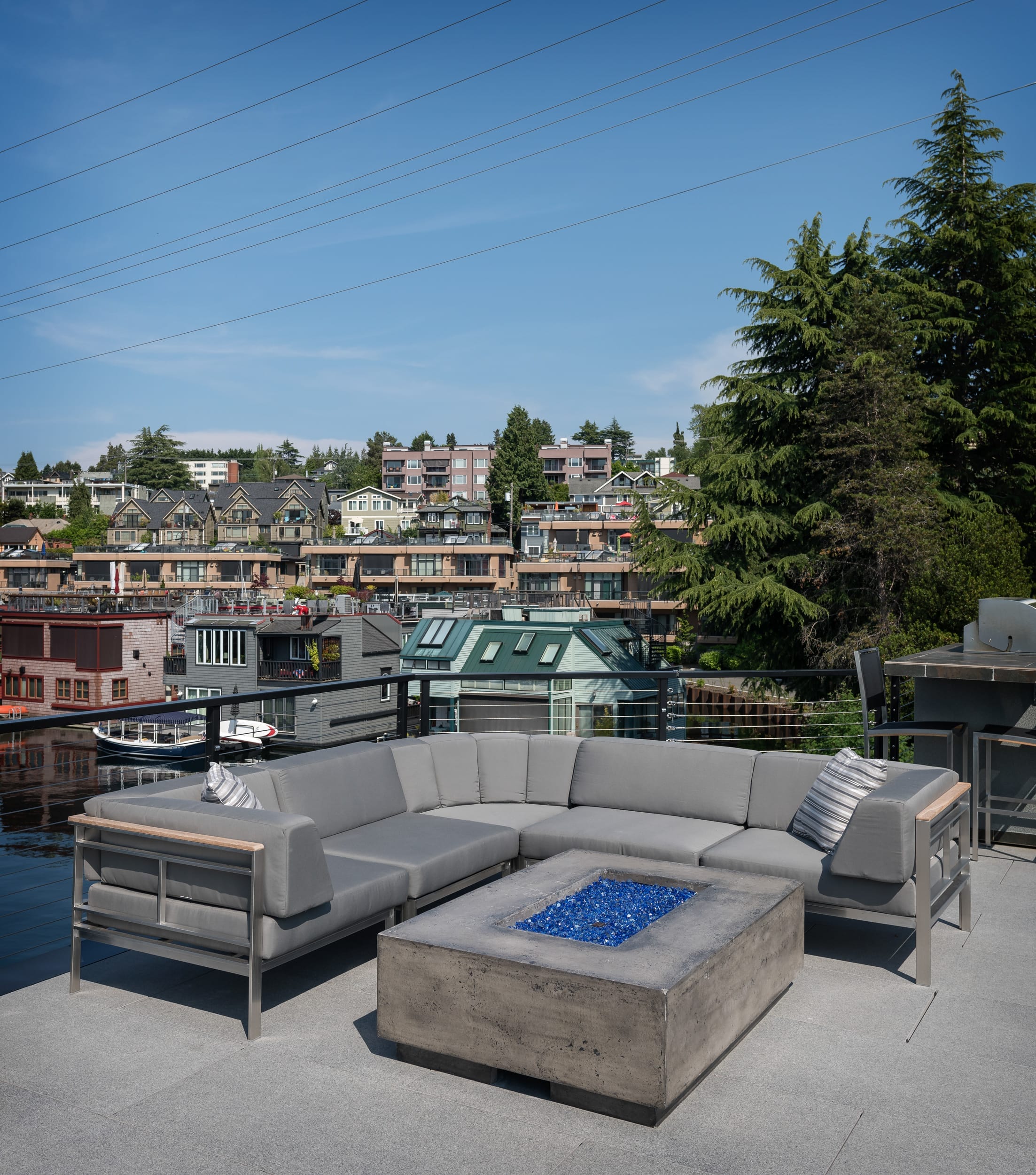 A modern gray couch on a deck overlooking a city.