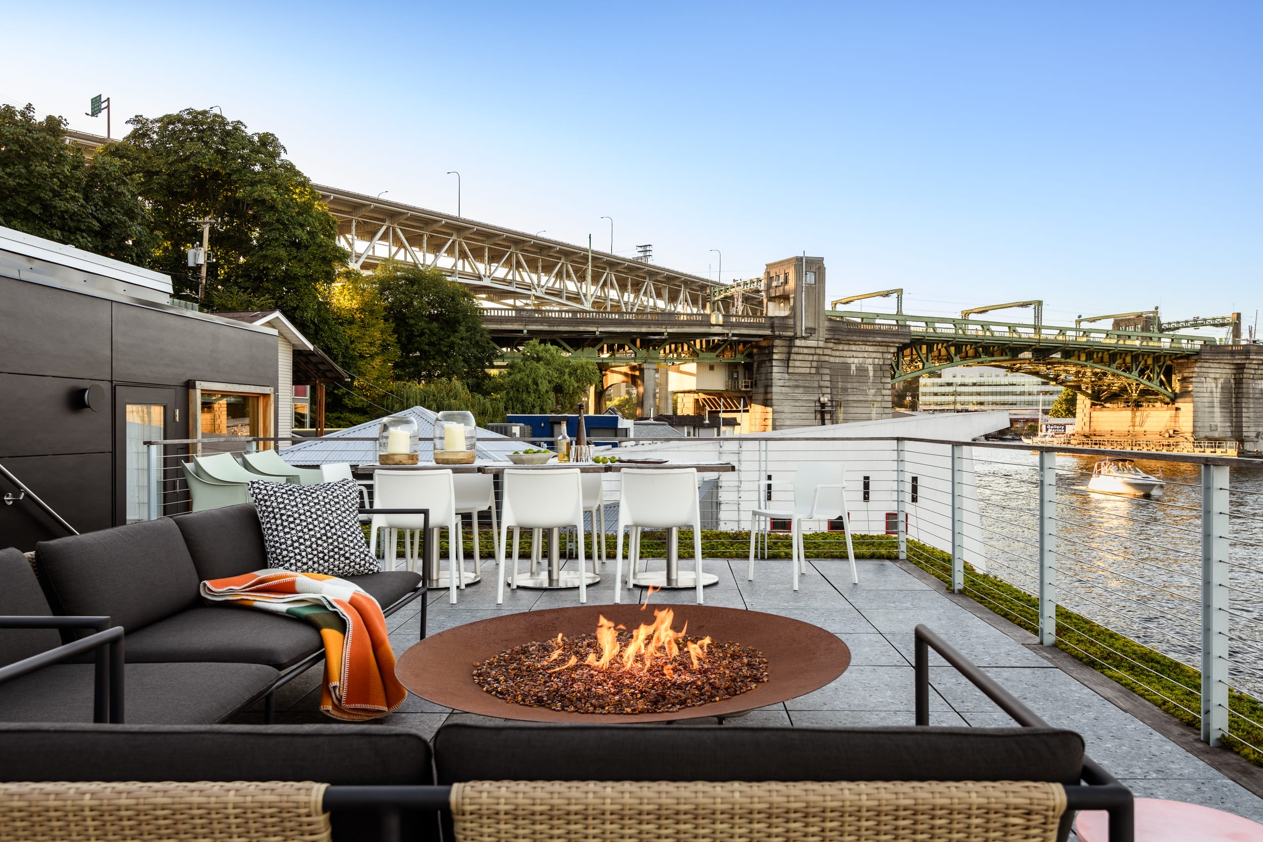 A fire pit on a deck overlooking a river.