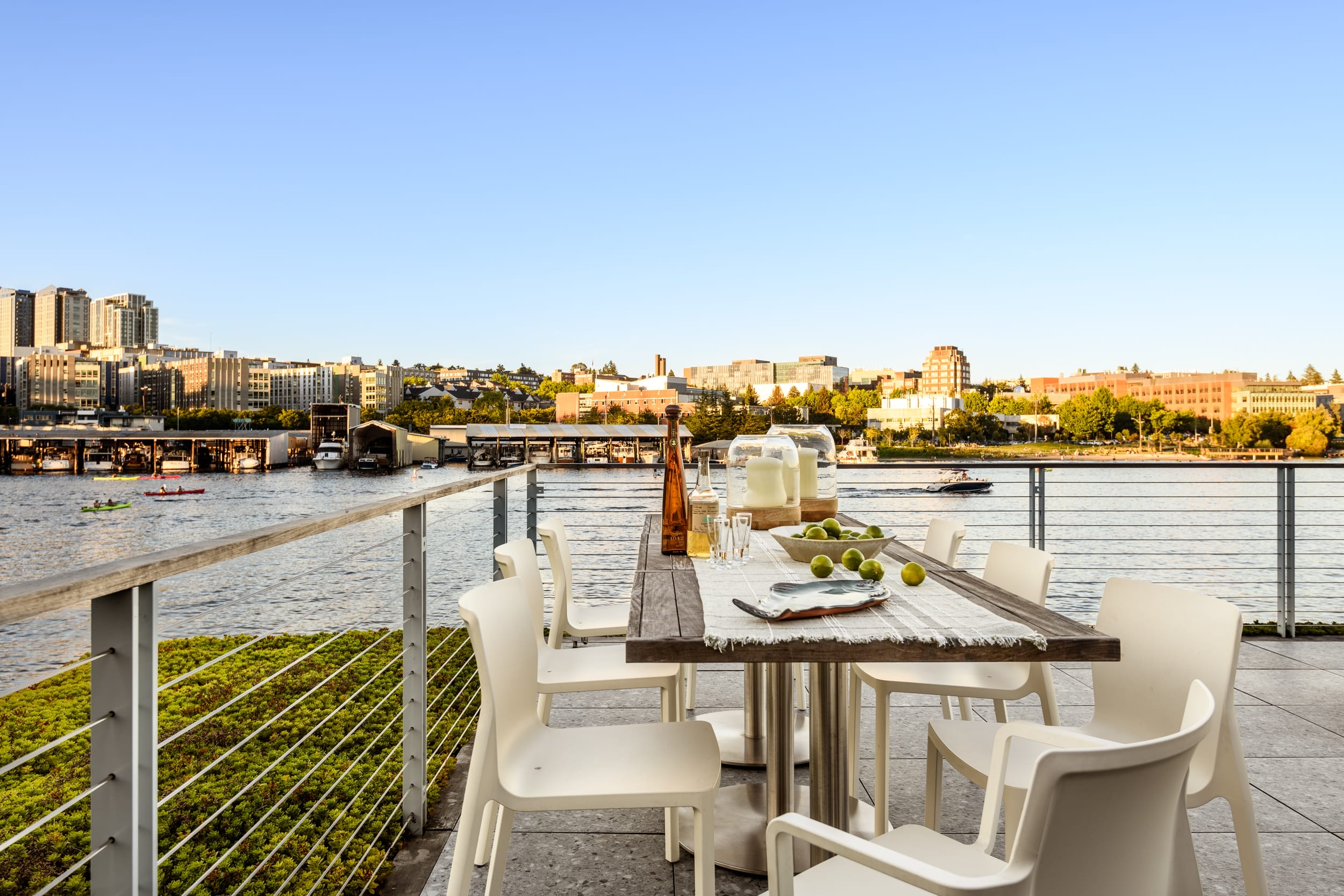 A white table and chairs on a balcony overlooking the river.