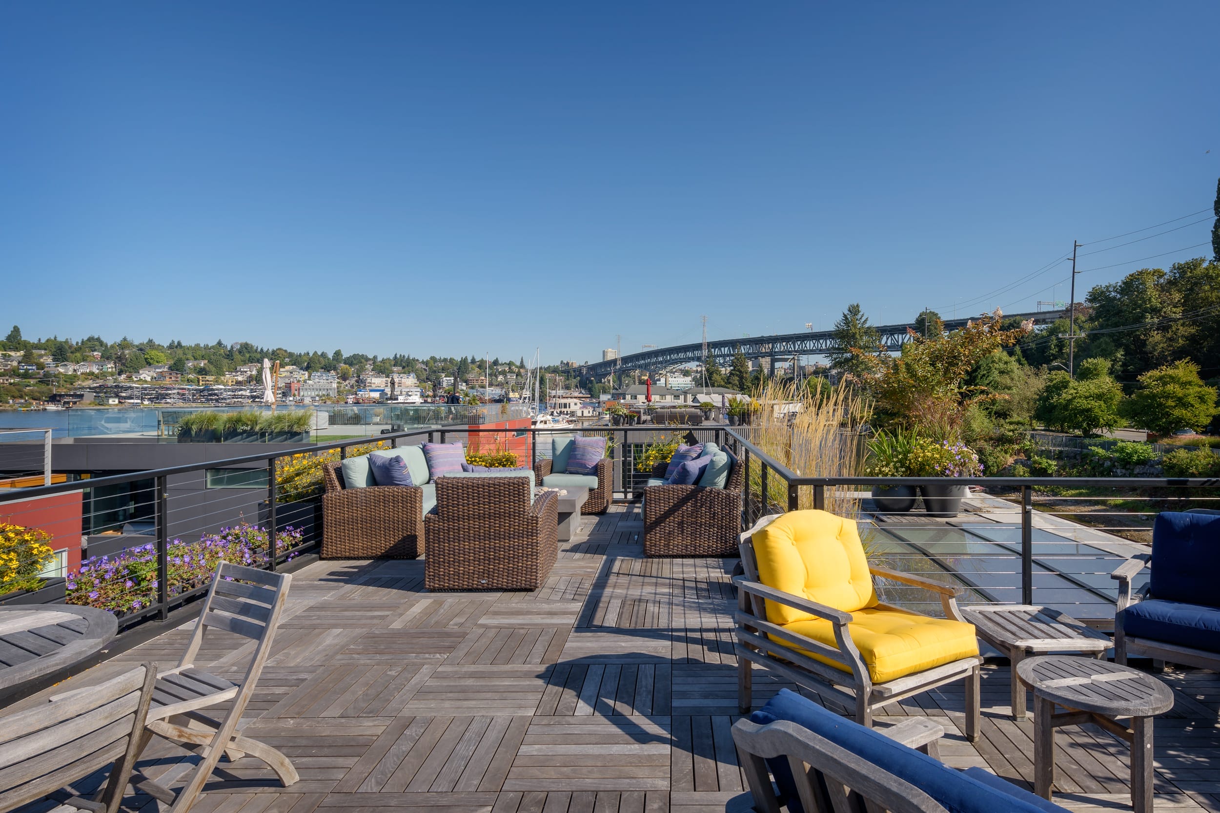 A rooftop deck with furniture and a view of the water.