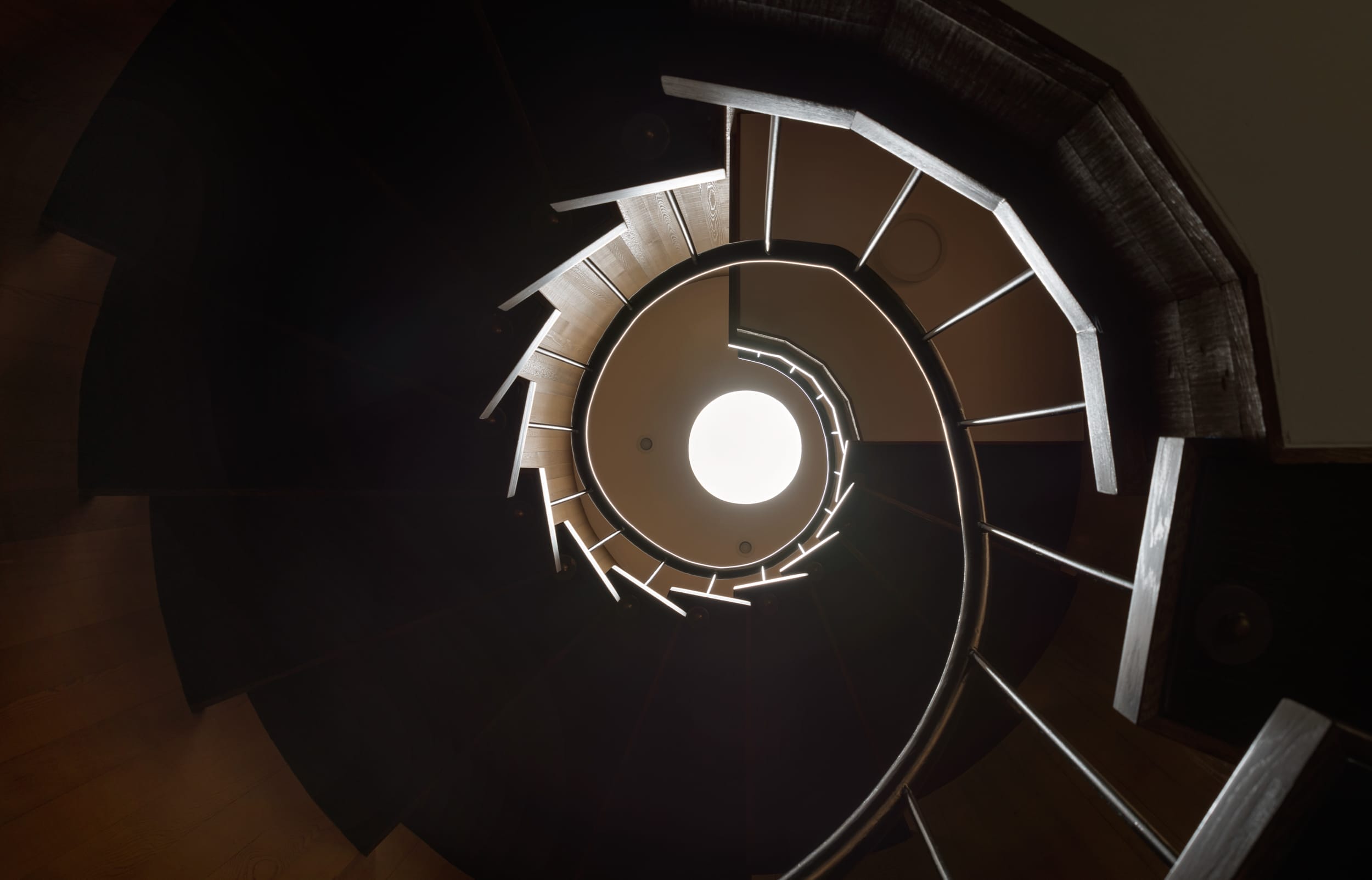 A spiral staircase with a light in the ceiling.