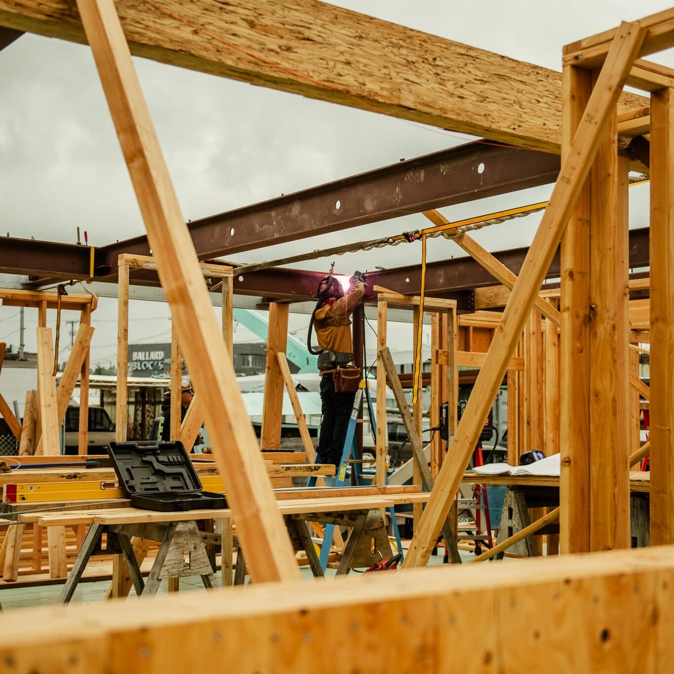 A man is working on a wooden frame in a construction site.