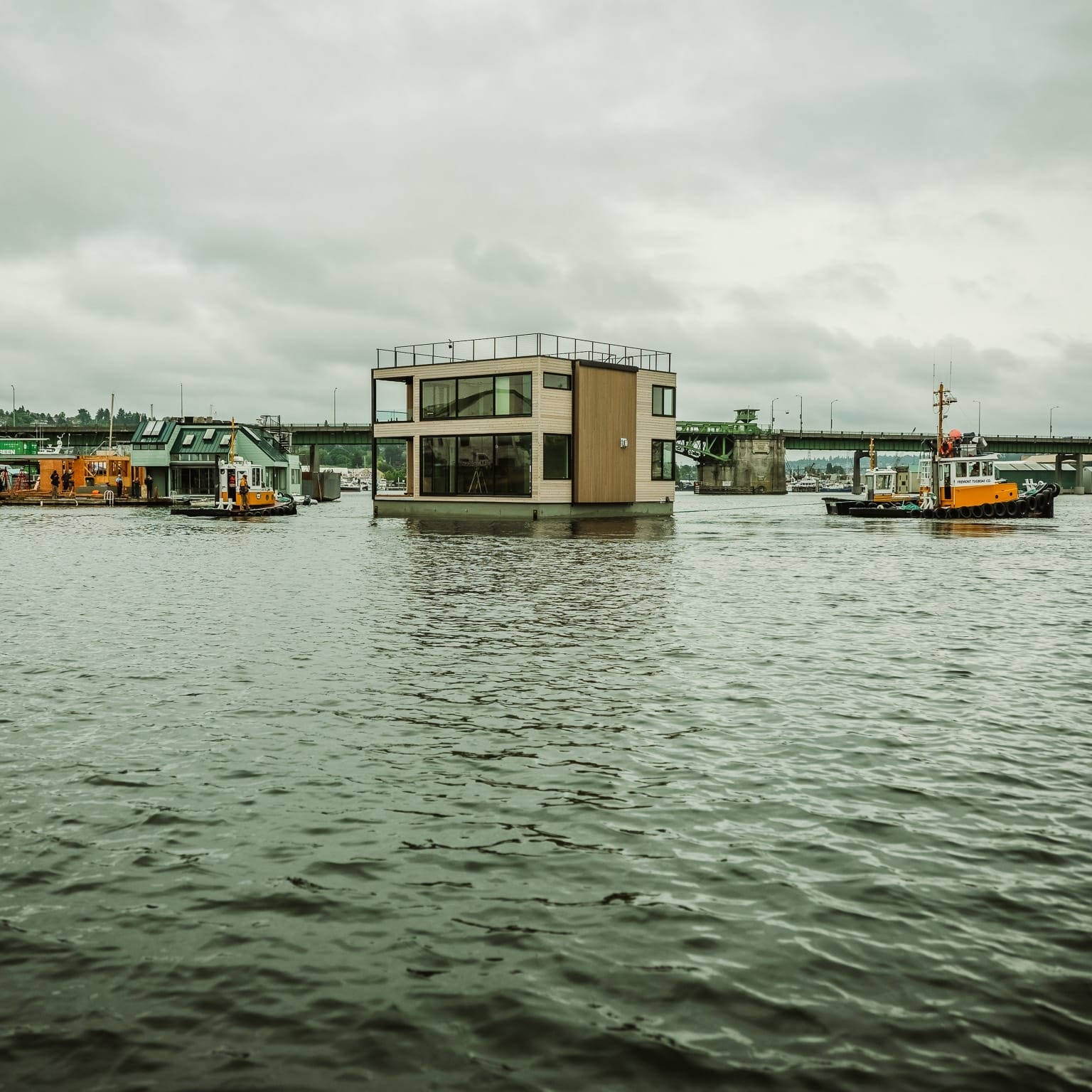 A boat is floating next to a house on Seattle Floating Homes.