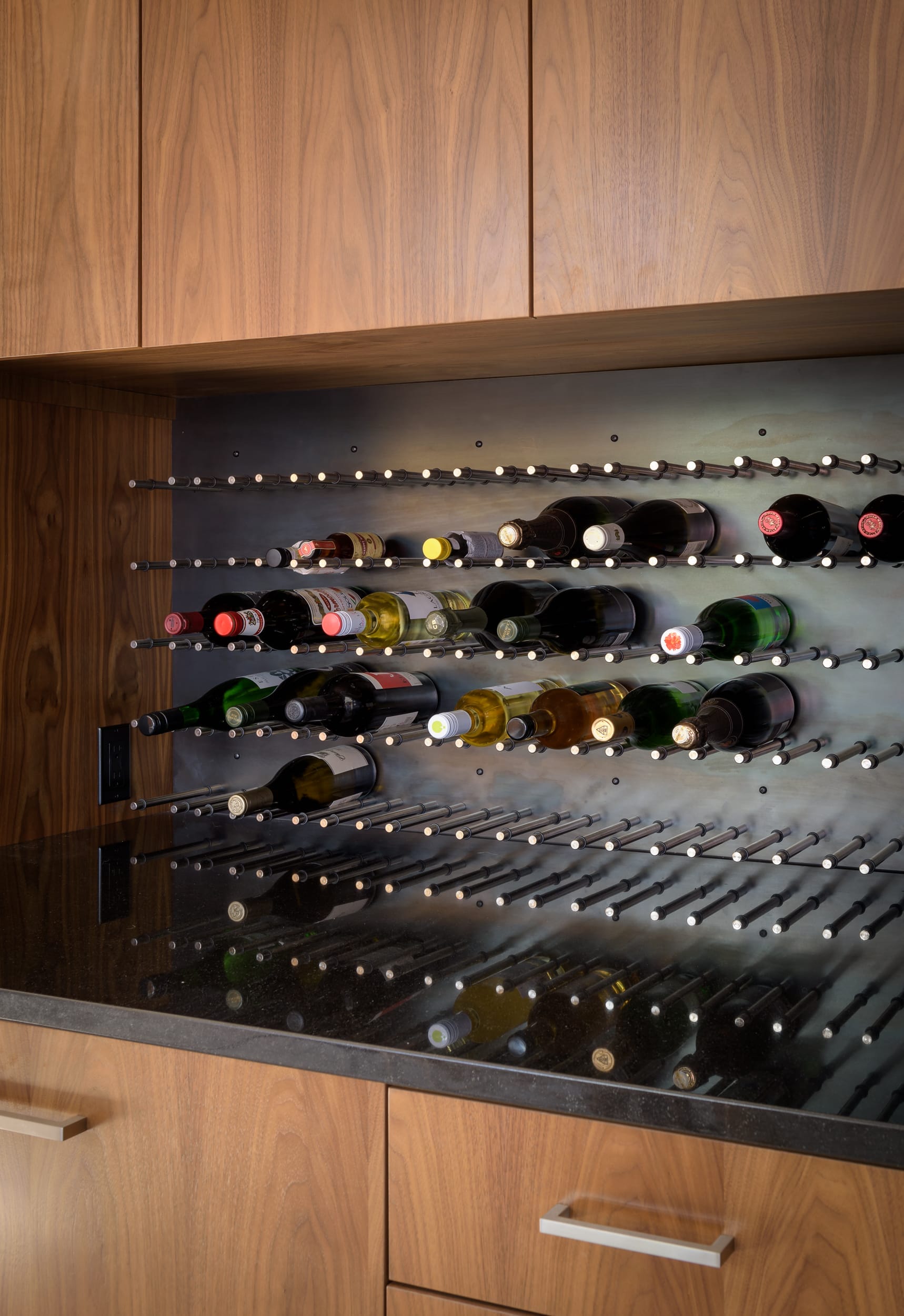 A kitchen with a wine rack full of bottles.